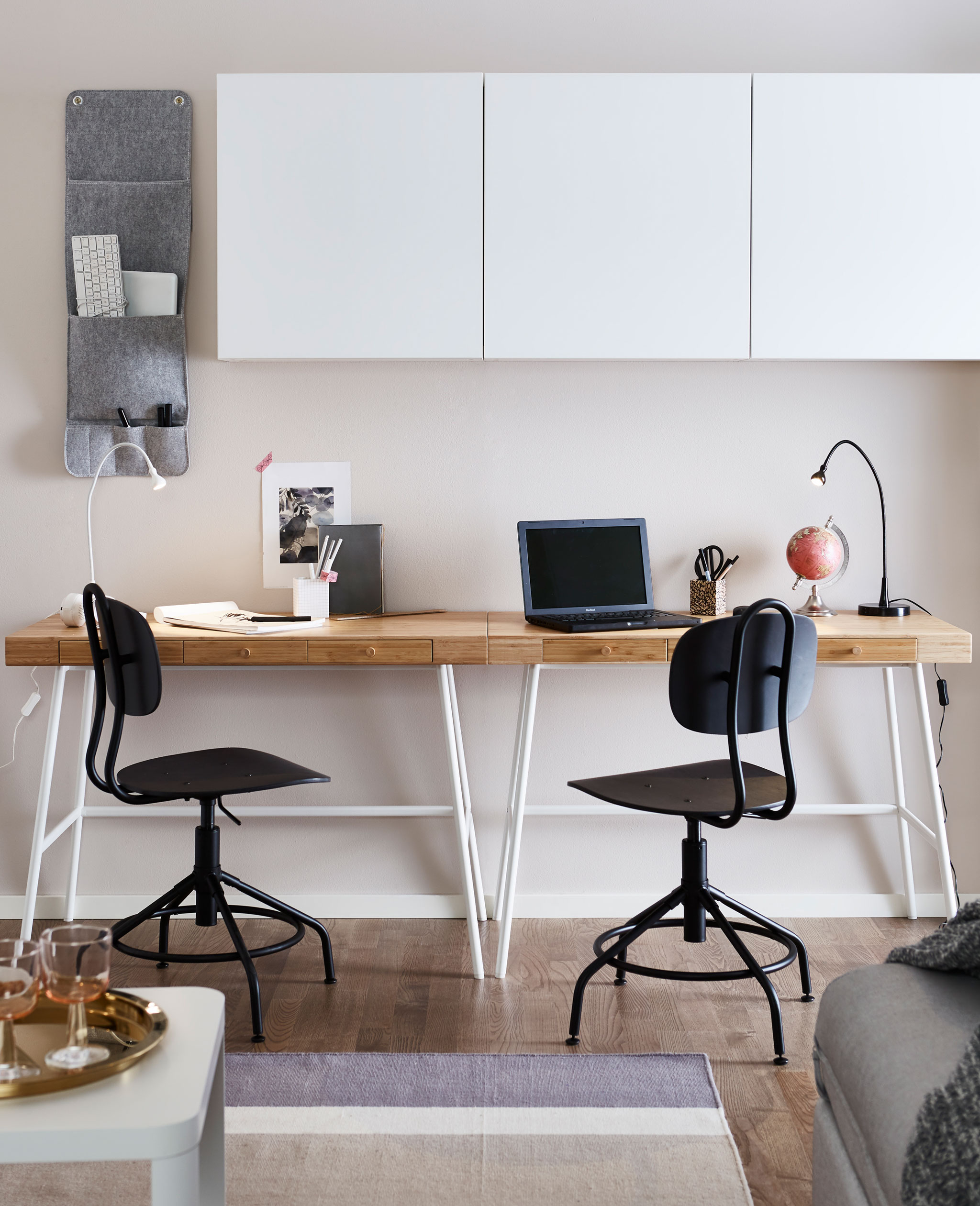 客厅,洁白的壁柜下方,两张书桌靠墙立着.