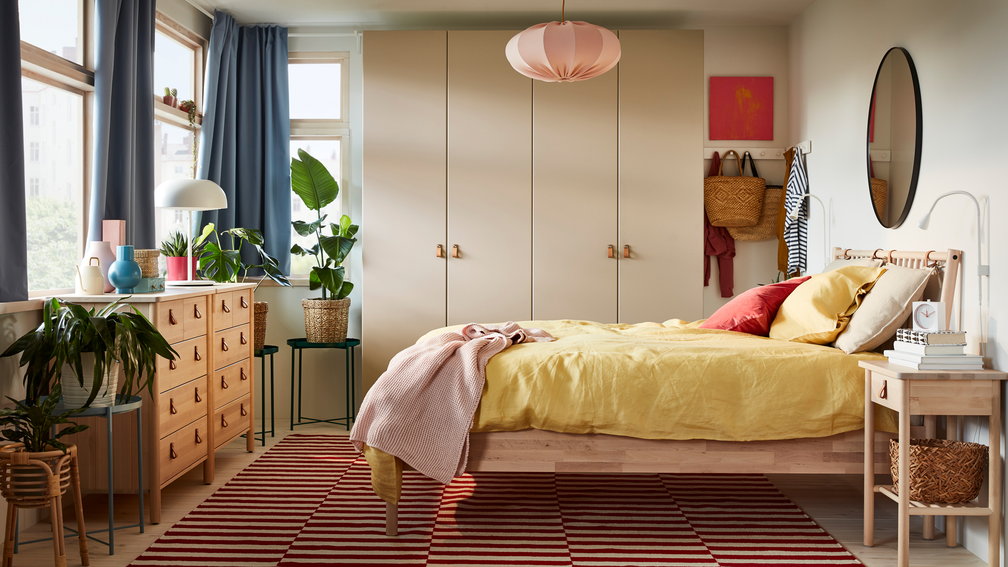 A bedroom containing BJÖRKSNÄS bed, chests of drawers and bedside table, with a PAX/REINSVOLL wardrobe and GLADOM tables.