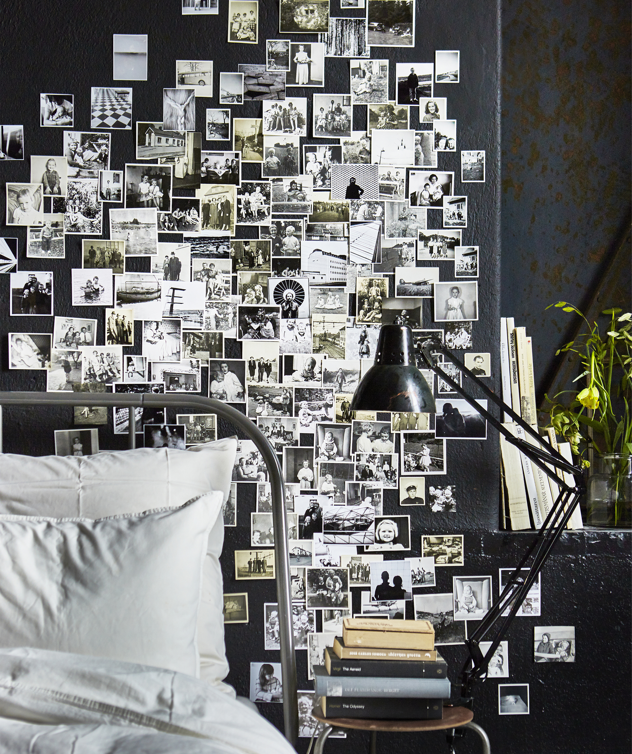 A bedroom wall covered in black and white family photos.