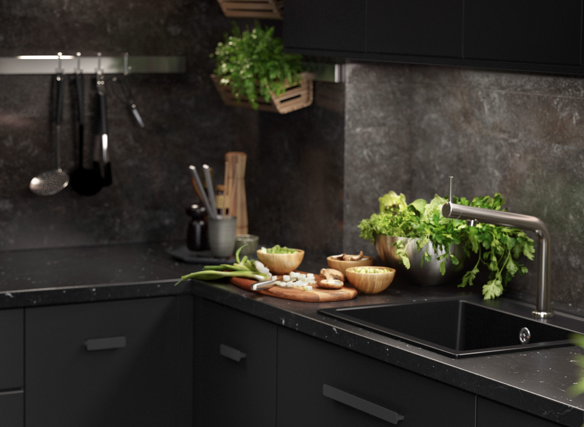 A black KUNGSBACKA kitchen with marble inspired features with kitchen utensils and fresh herbs.