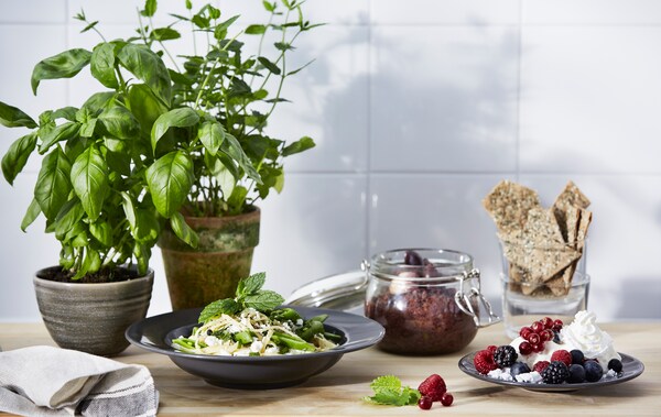 A bowl of pasta, a plate of tapenade and a meringue dessert on a table