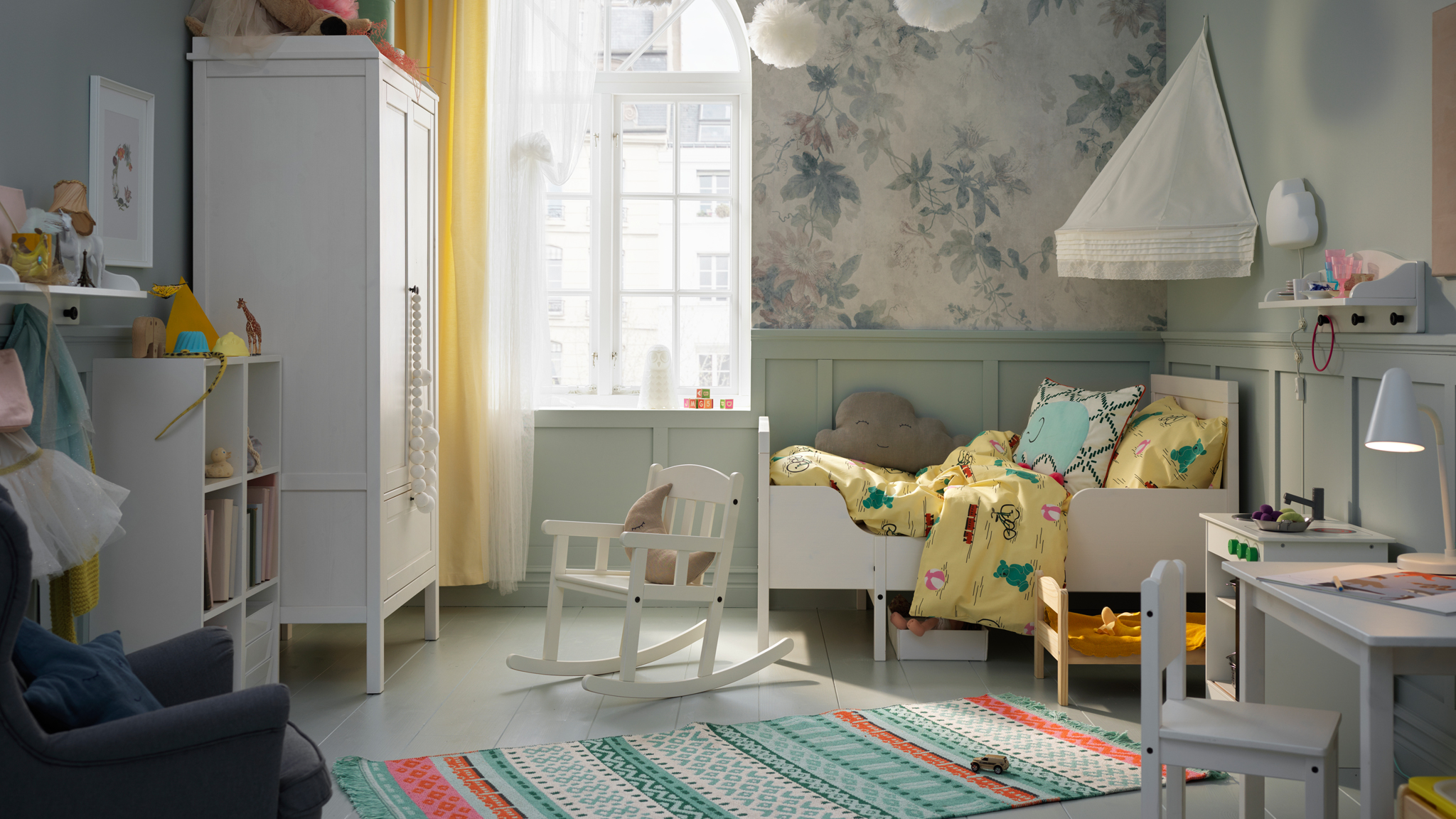 A child’s bedroom with a SUNDVIK extendable bed, wardrobe and rocking-chair. A KÄPPHÄST rug lies on the floor.