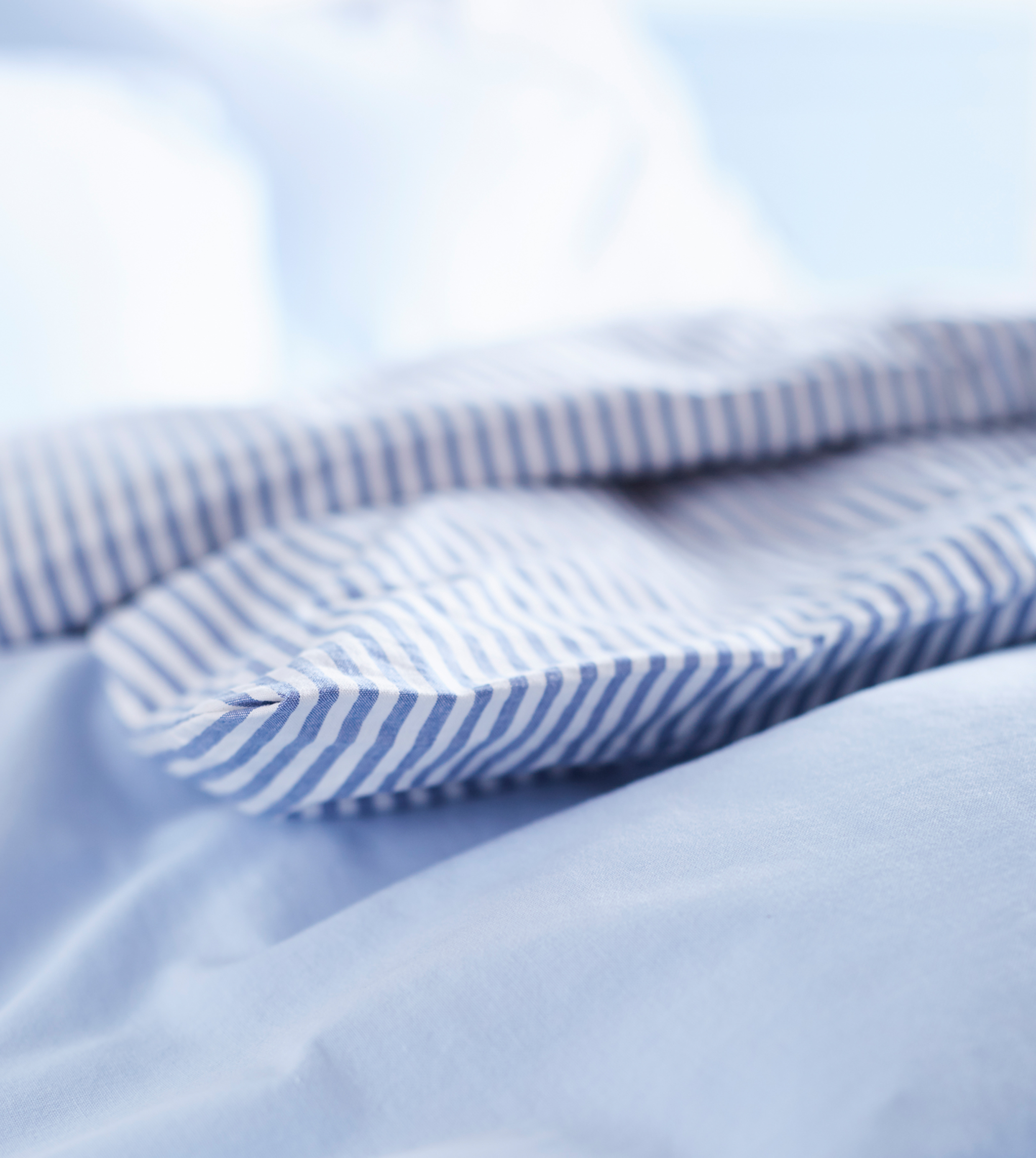 A close-up image of white and blue bed linens.
