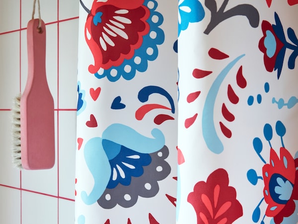 A close-up of KRATTEN shower curtain featuring a traditional Scandinavian, floral pattern in many colours.