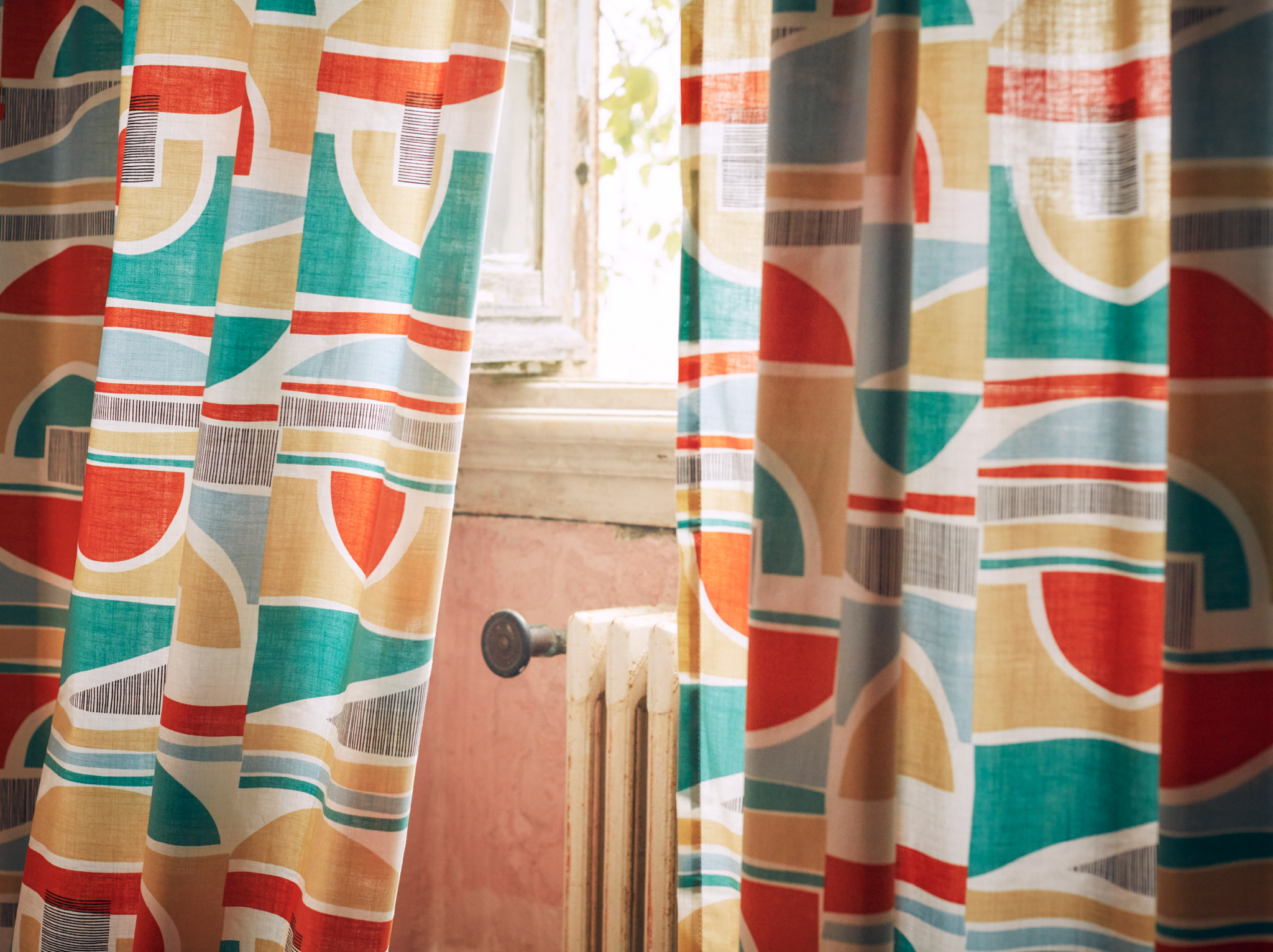 A close-up of MARTORN curtains with a multi-coloured graphic pattern that looks like it could be taken from the 1960s.