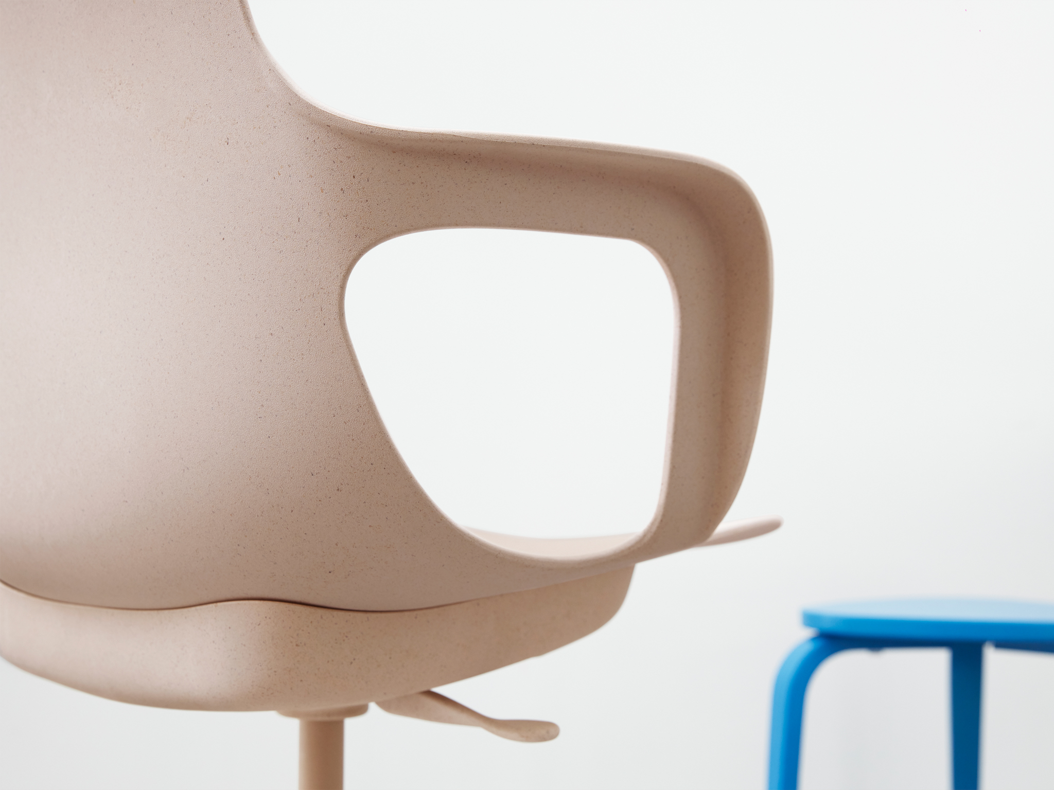 A close-up of ODGER swivel chair with its bowl-shaped seat, rounded back and armrests available in white/beige or black.