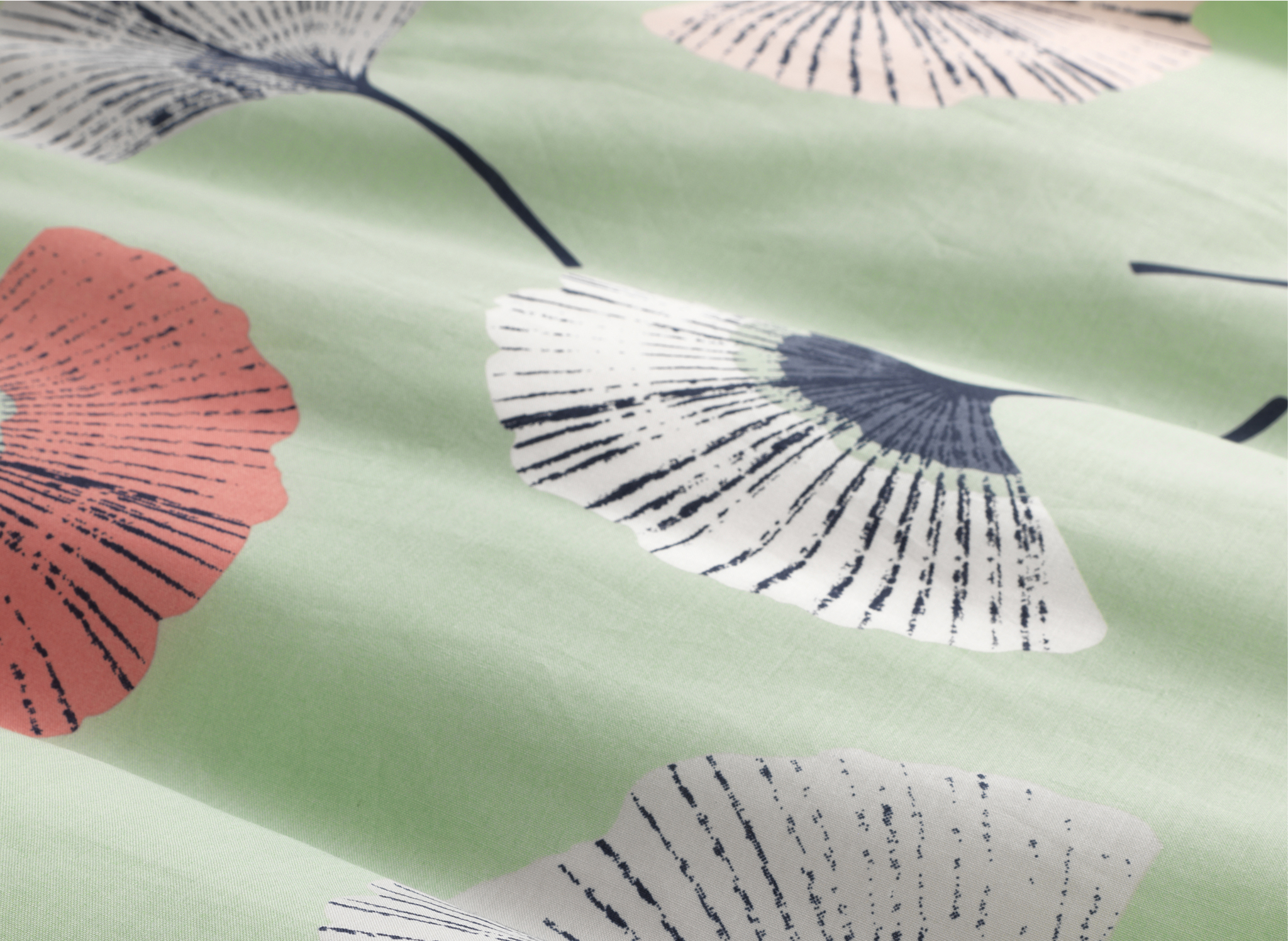A close-up of pale green fabric with flower pattern.
