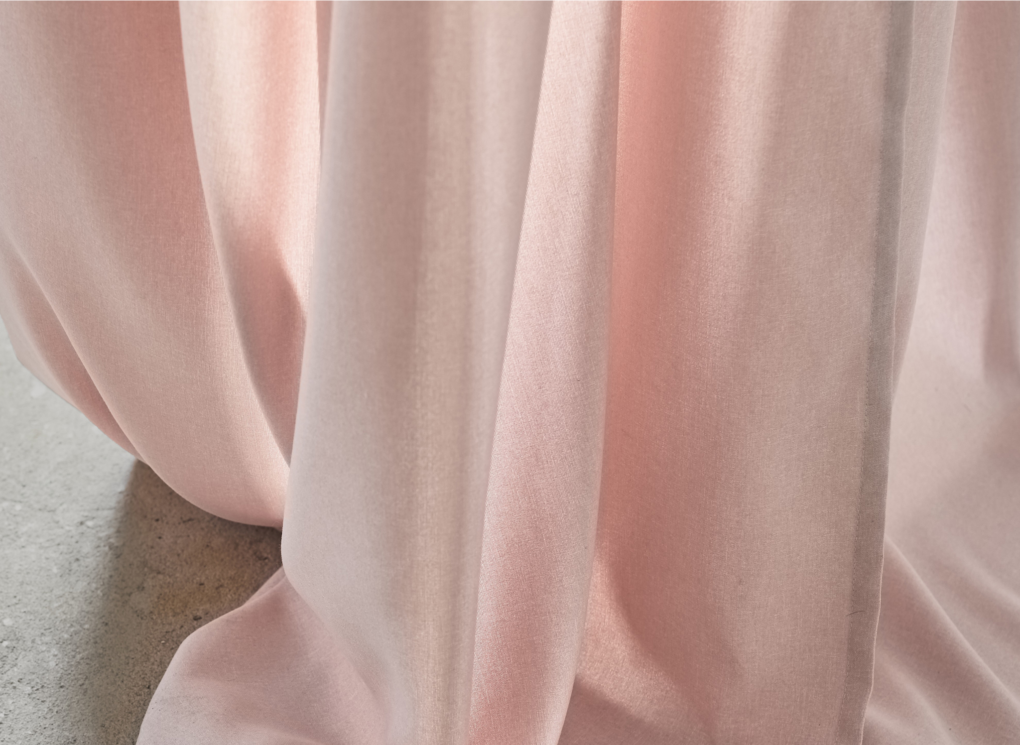 A close-up on pink curtain fabric.