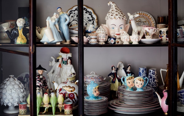 A collection of china ornaments in a glass-fronted cabinet.