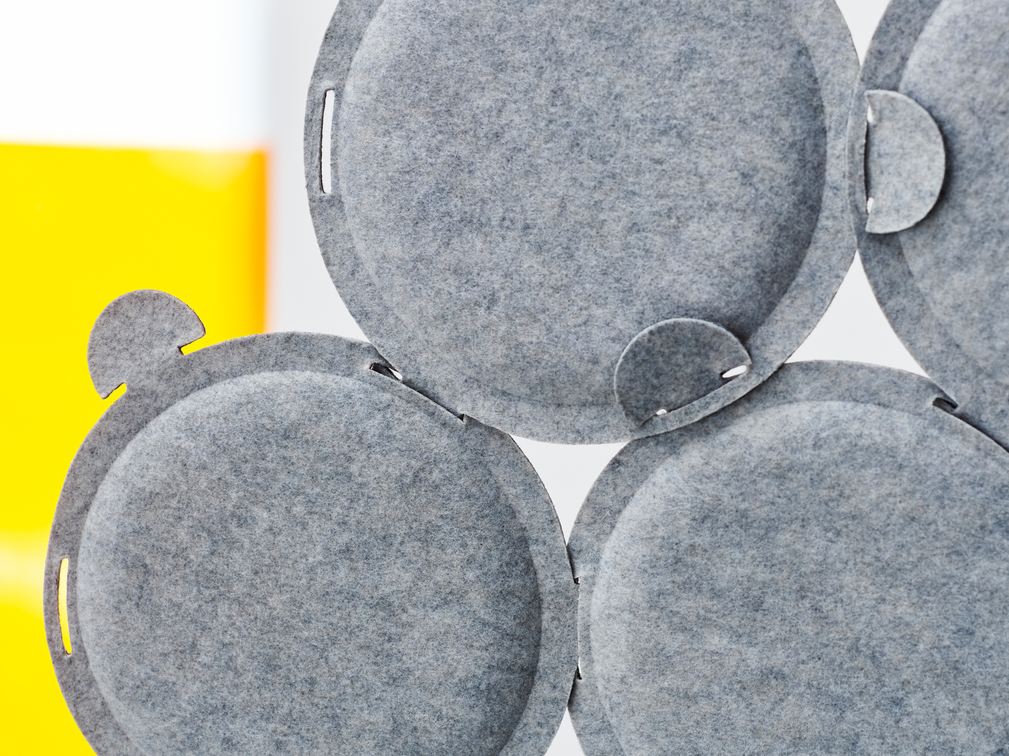 A few circular ODDLAUG sound absorbing panels made in grey felt attached together to absorb annoying sounds.