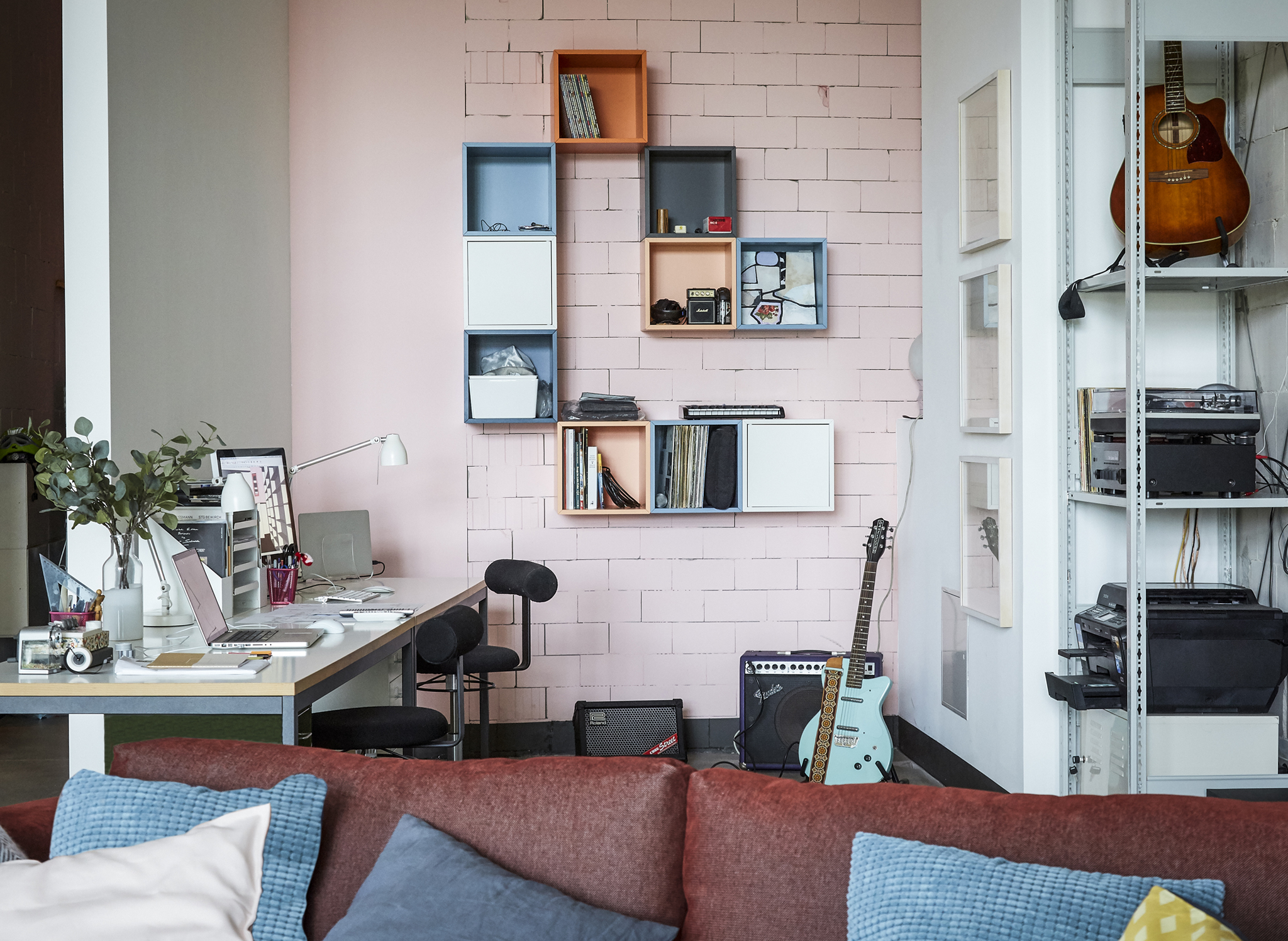 A home office with pink wall.