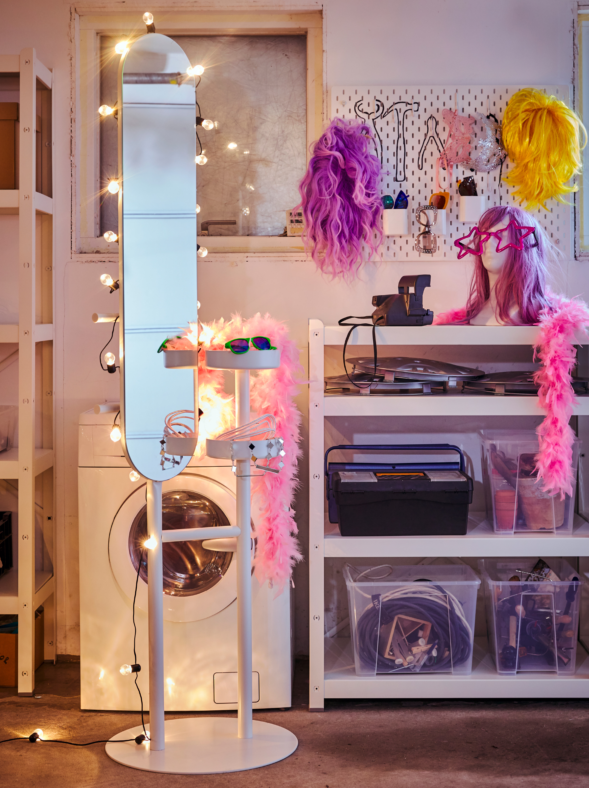 A LIERSKOGEN valet stand decorated with a BLÖTSNÖ lighting chain, standing near a SKÅDIS pegboard with wigs and accessories.