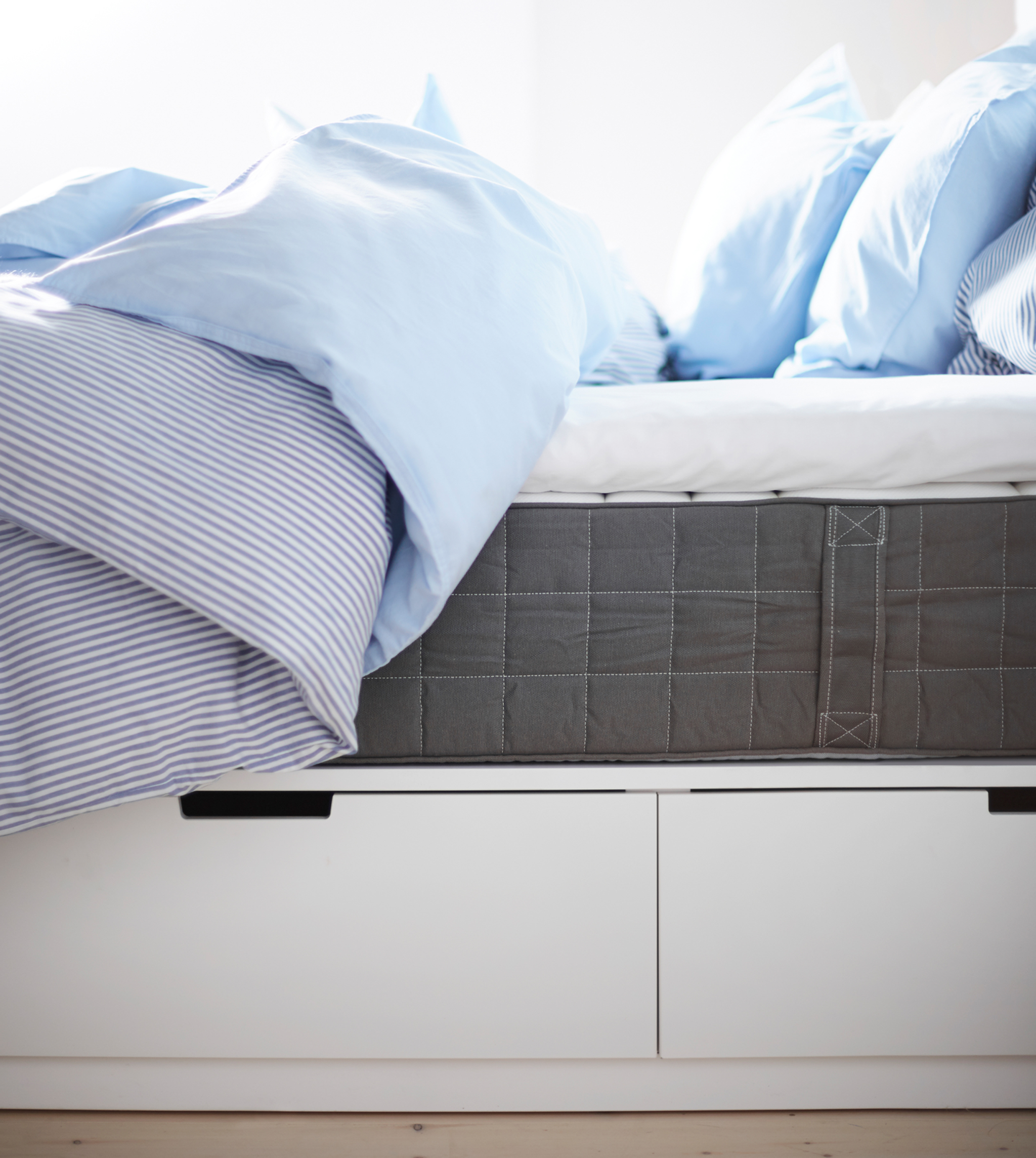 A sideview of a bed shows the under-bed storage and mattress.
