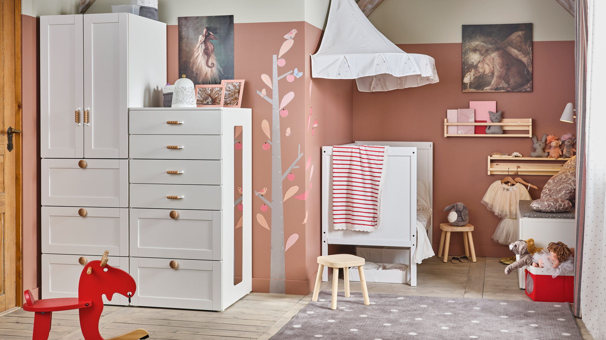 A white and pink traditional children’s room with SMÅSTAD storage, a SUNDVIK cot, and FLISAT children’s stools.