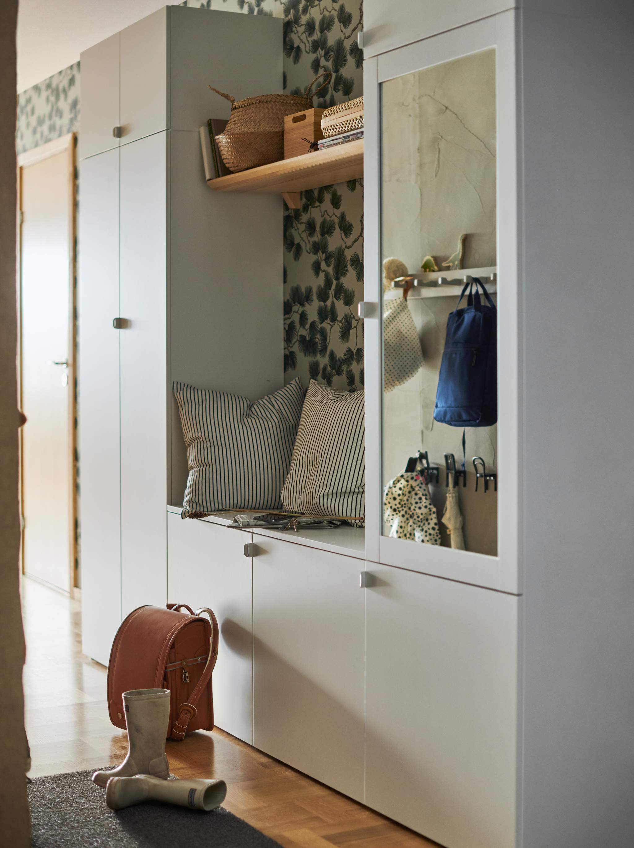 A white hallway combination made from a PLATSA wardrobe with nine doors, with a space in the middle used for sitting.