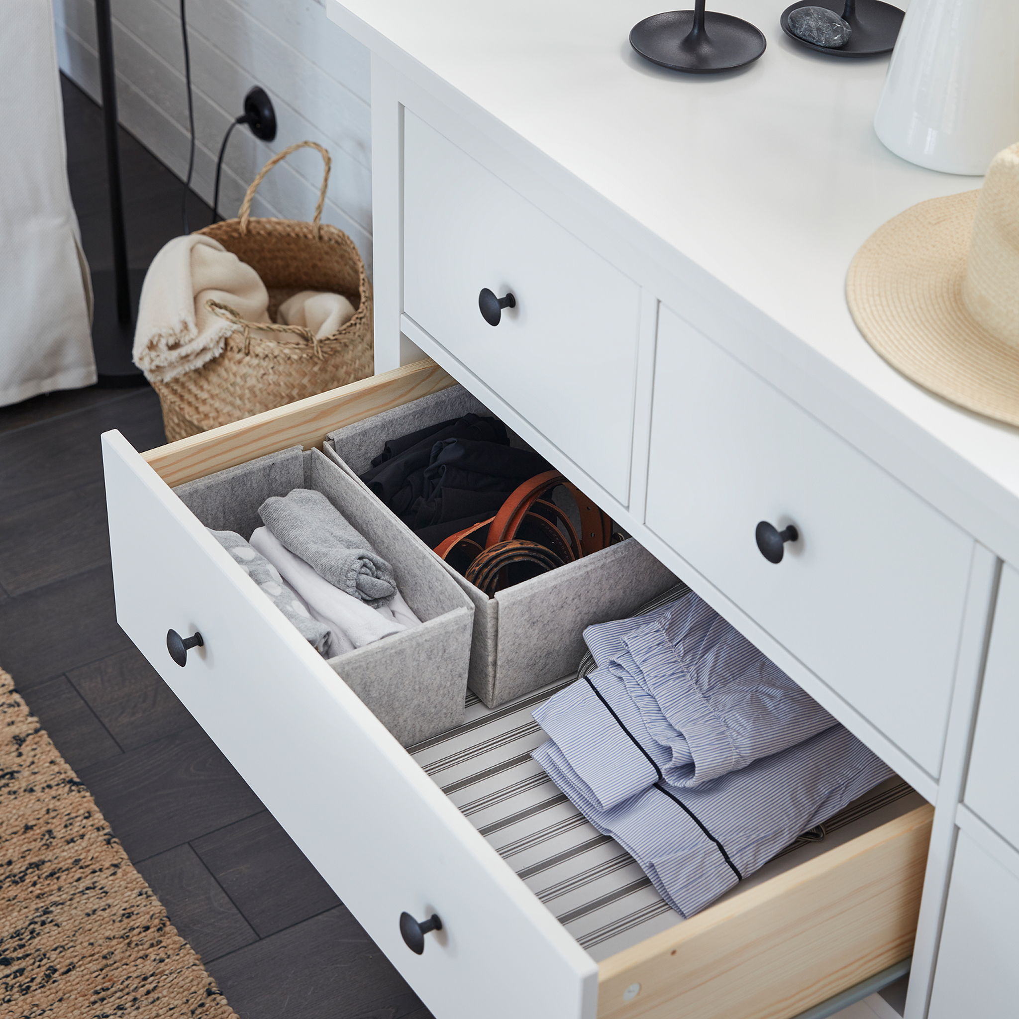A white HEMNES chest of drawers is open, and KOMPLEMENT light grey boxes inside help organise clothes.