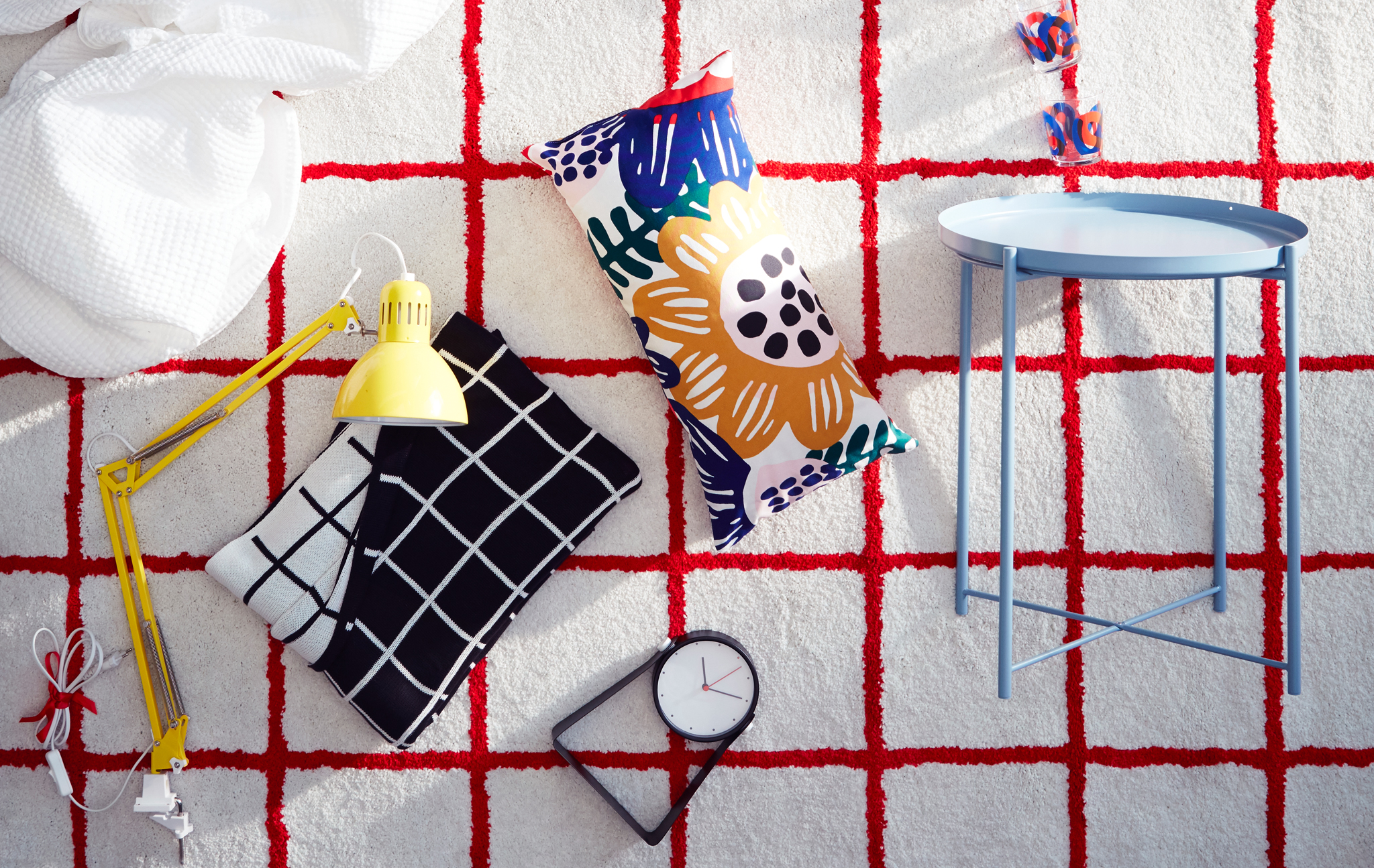 A white IKEA SIMESTED rug with a bright red square pattern and high pile is the backdrop for matching products.