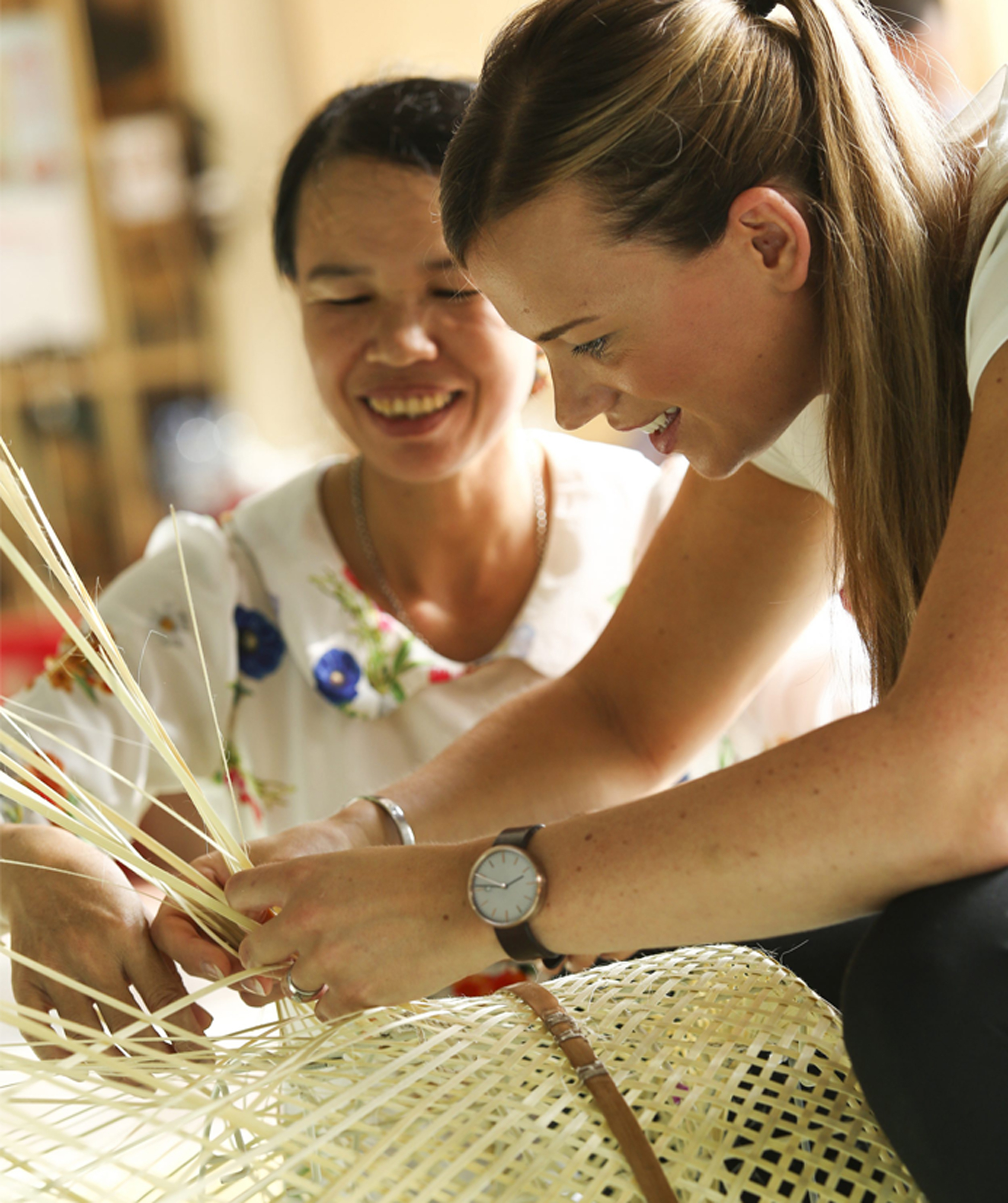 A woman teaching traditional bamboo weaving techniques to Anna Granath.