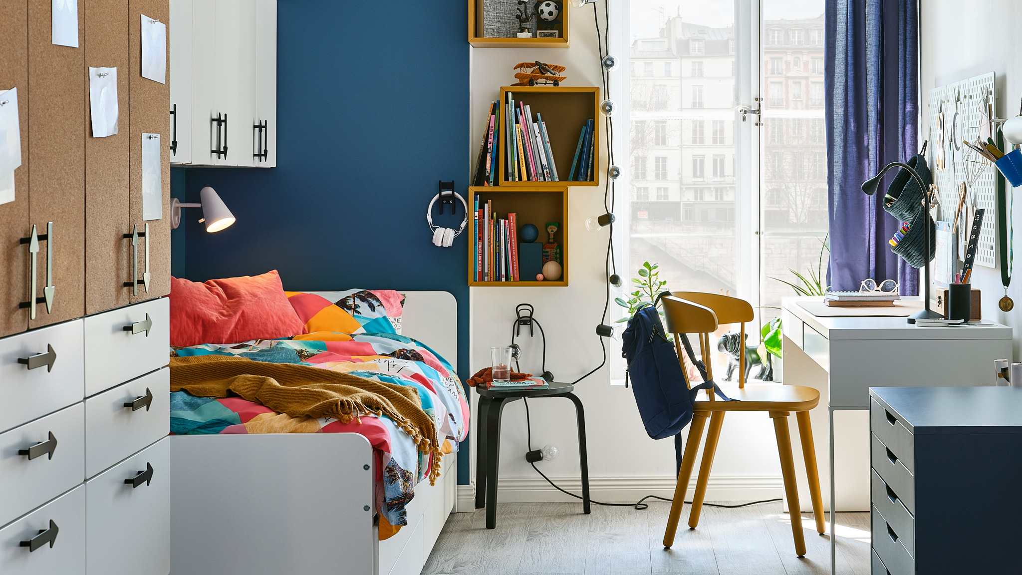 An older child’s bedroom with a SMÅSTAD wardrobe and a SLÄKT bed opposite an OMTÄNKSAM chair and a MICKE desk.