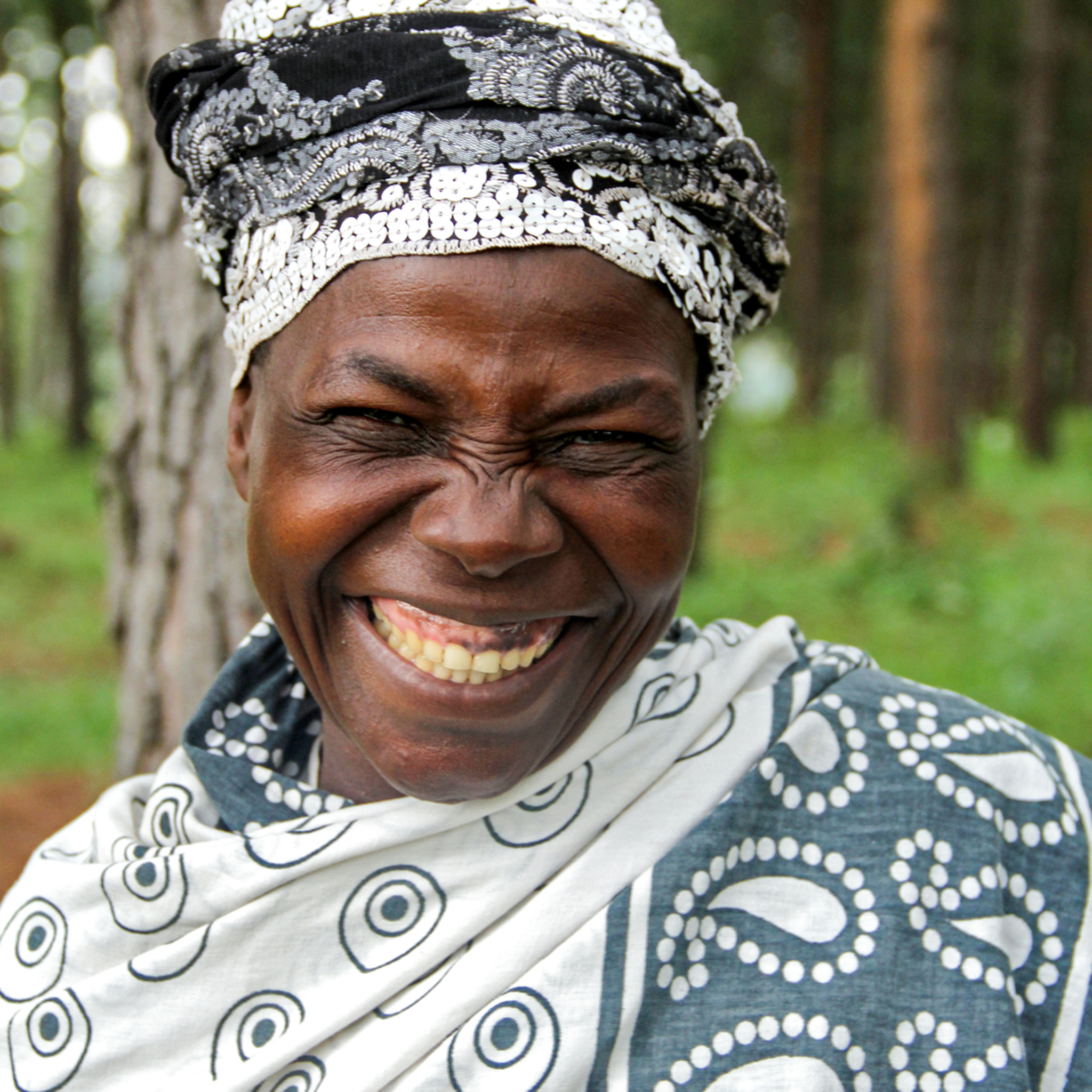 An Ugandan woman, broadly smiling, who’s involved in the White Nile project.