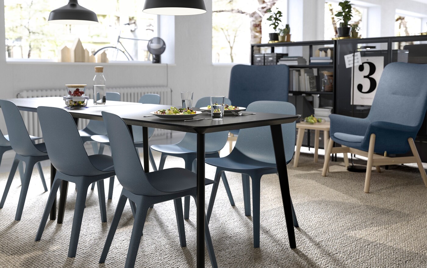 IKEA ODGER bowl-shaped black chairs and LISABO black rectangular dining table in an open break eating area.
