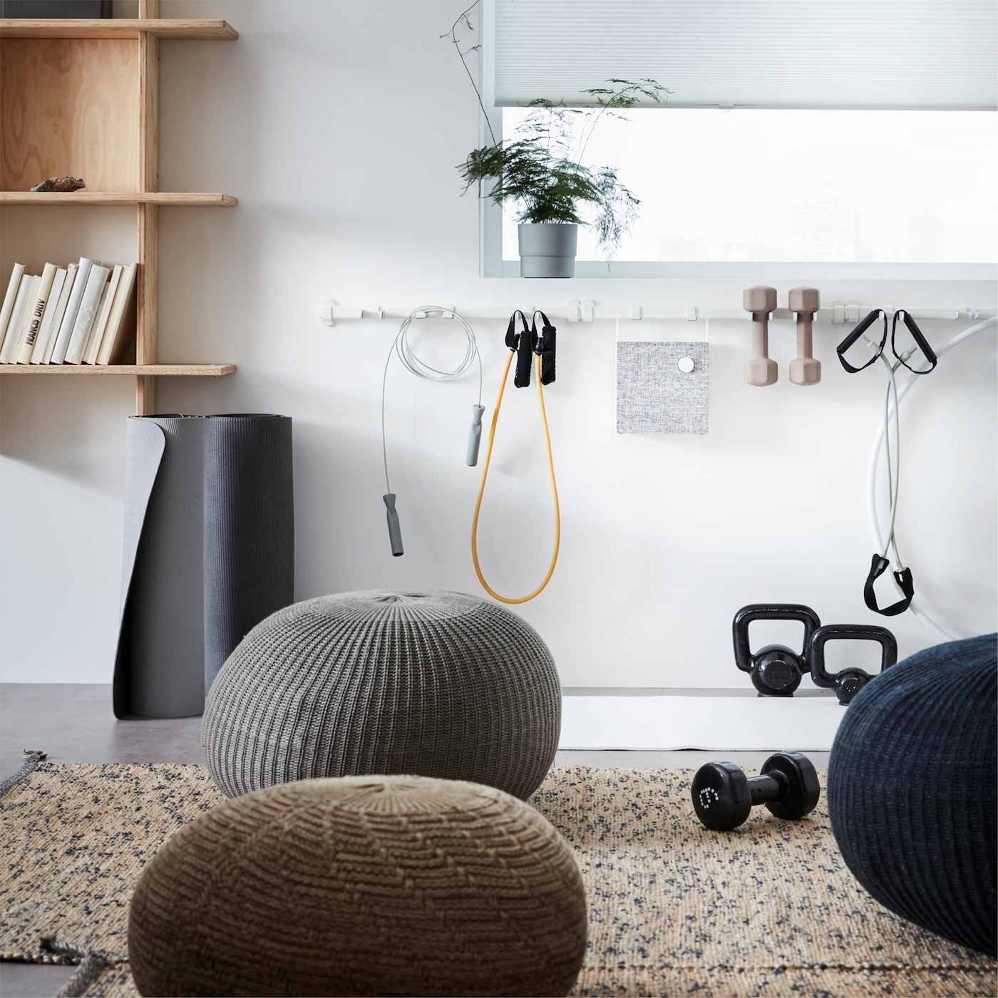 SANDARED pouffes scattered in a relaxation area of an office, with an IKEA VAJERT white rail hung with sport equipment.