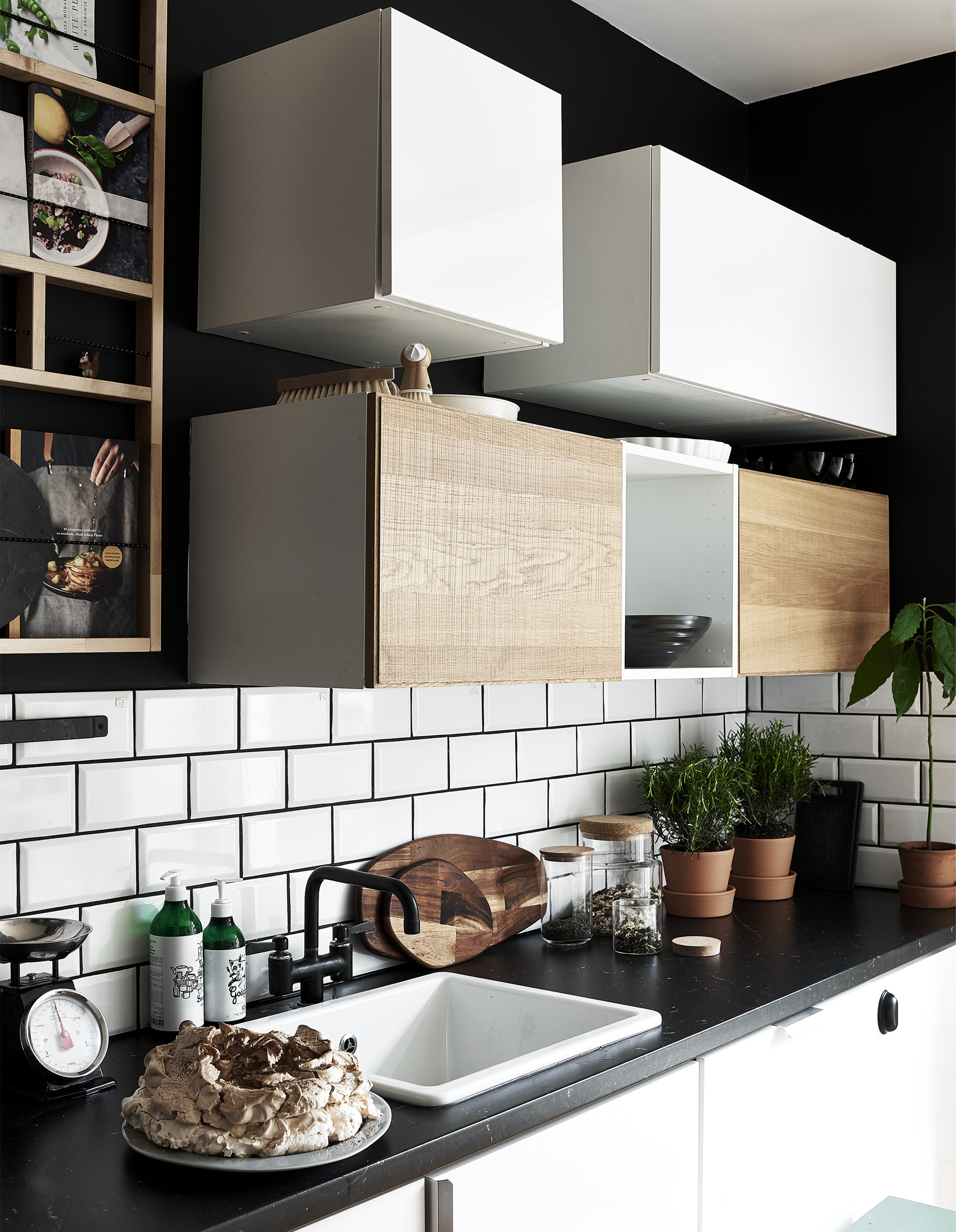 Cabinets hung on a wall above a worktop in a black-and-white kitchen.