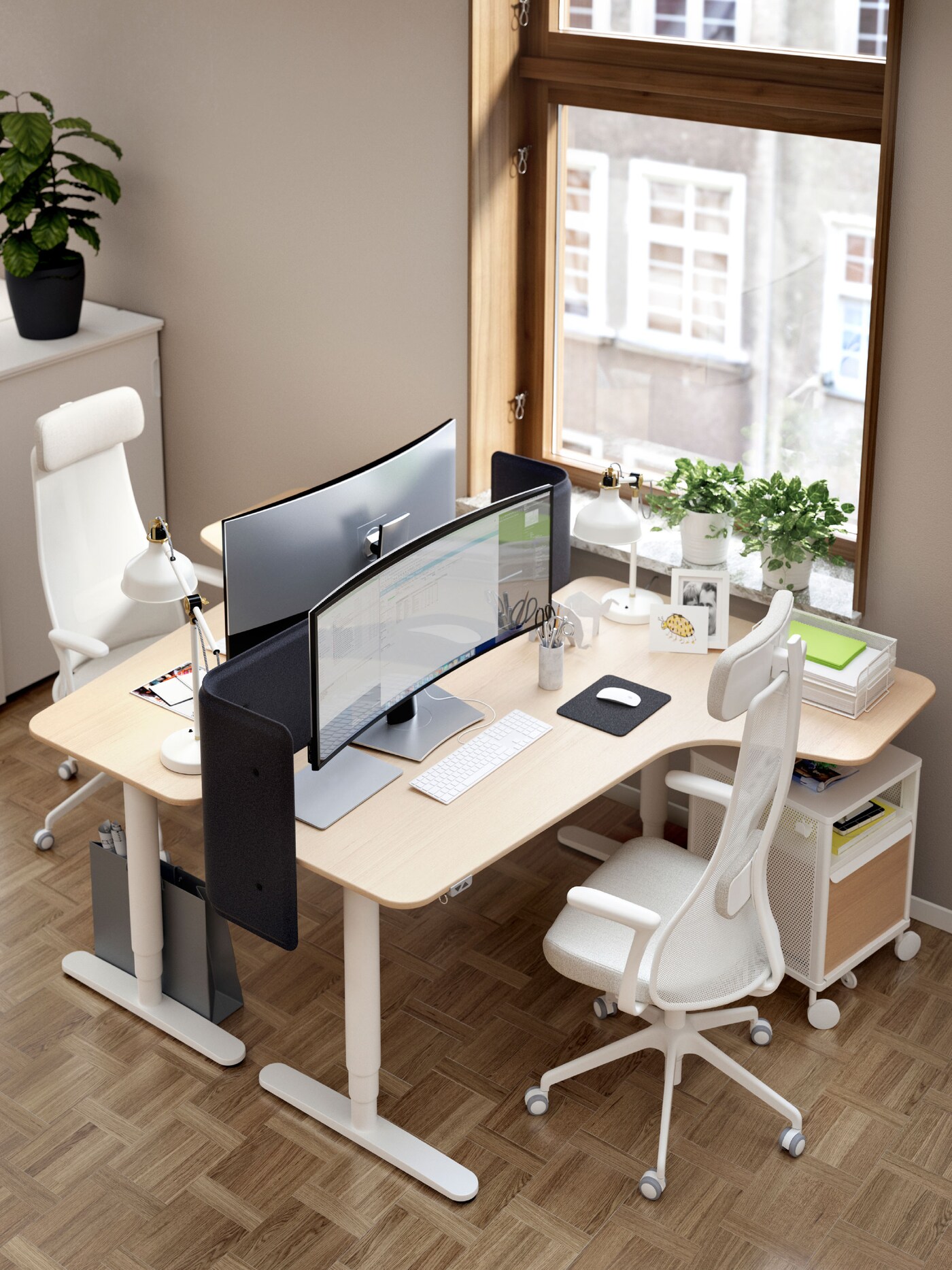 Two BEKANT corner desks facing each other beside a large window. Each desk has a JÄRVFJÄLLET chair and a BEKANT storage unit.