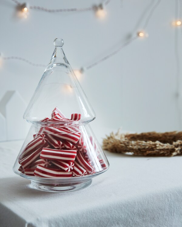Clear glass VINTERFEST serving bowl filled with red and white striped candy on a white table cloth.