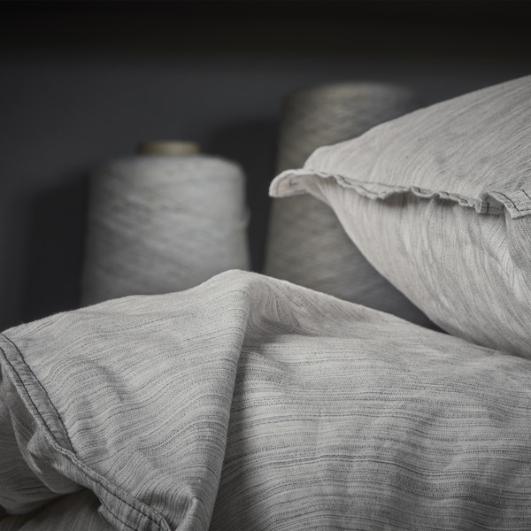 Close-up of a quilt cover and pillowcase made of beige 100% cotton with fine shifting colours.