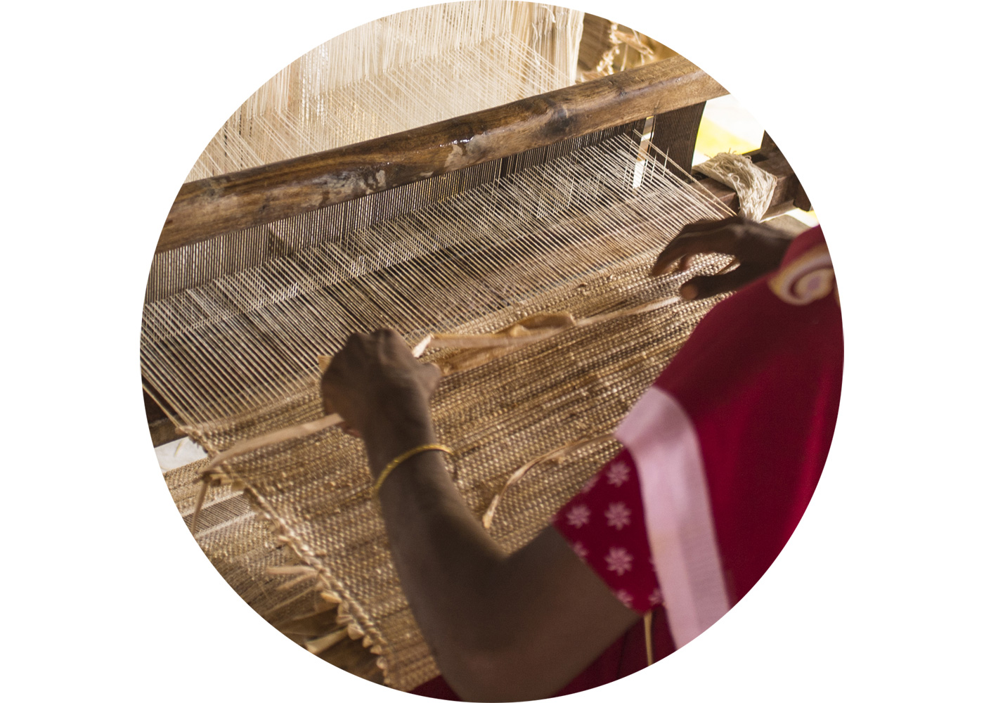 Close-up of a woman weaving a rug with a loom.