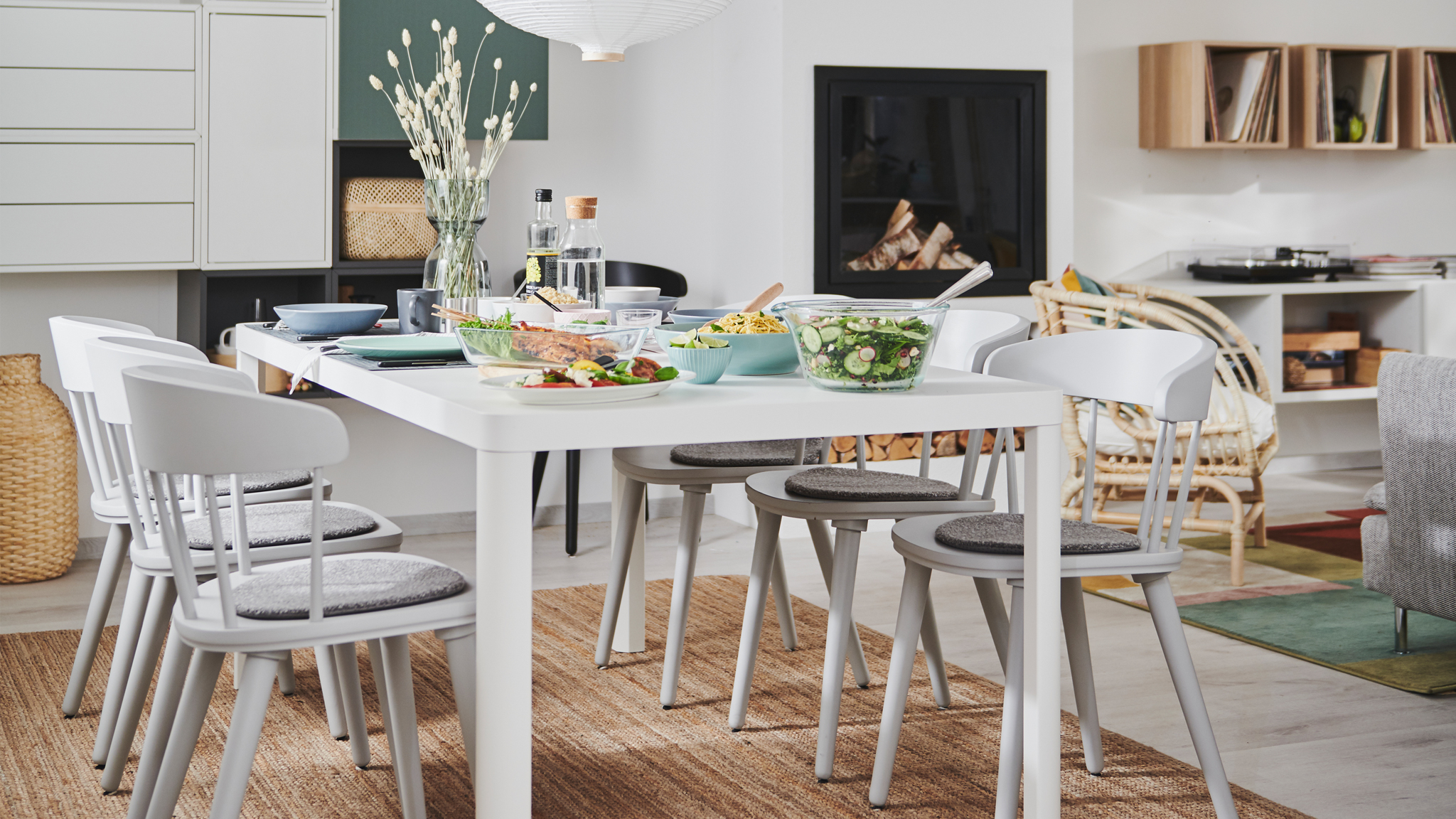Combined living and dining room interior with fireplace, wall storage and a TINGBY dining table with OMTÄNKSAM chairs.