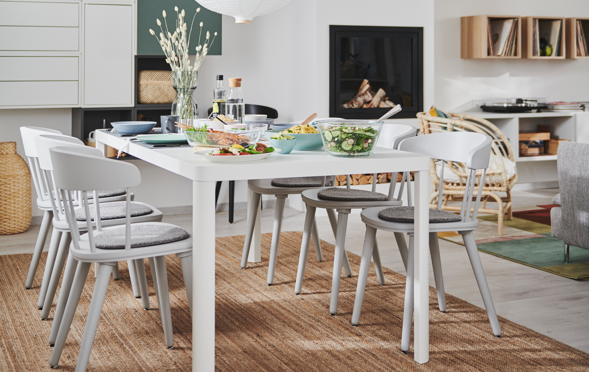 Combined living and dining room interior with fireplace, wall storage and a TINGBY dining table with OMTÄNKSAM chairs.