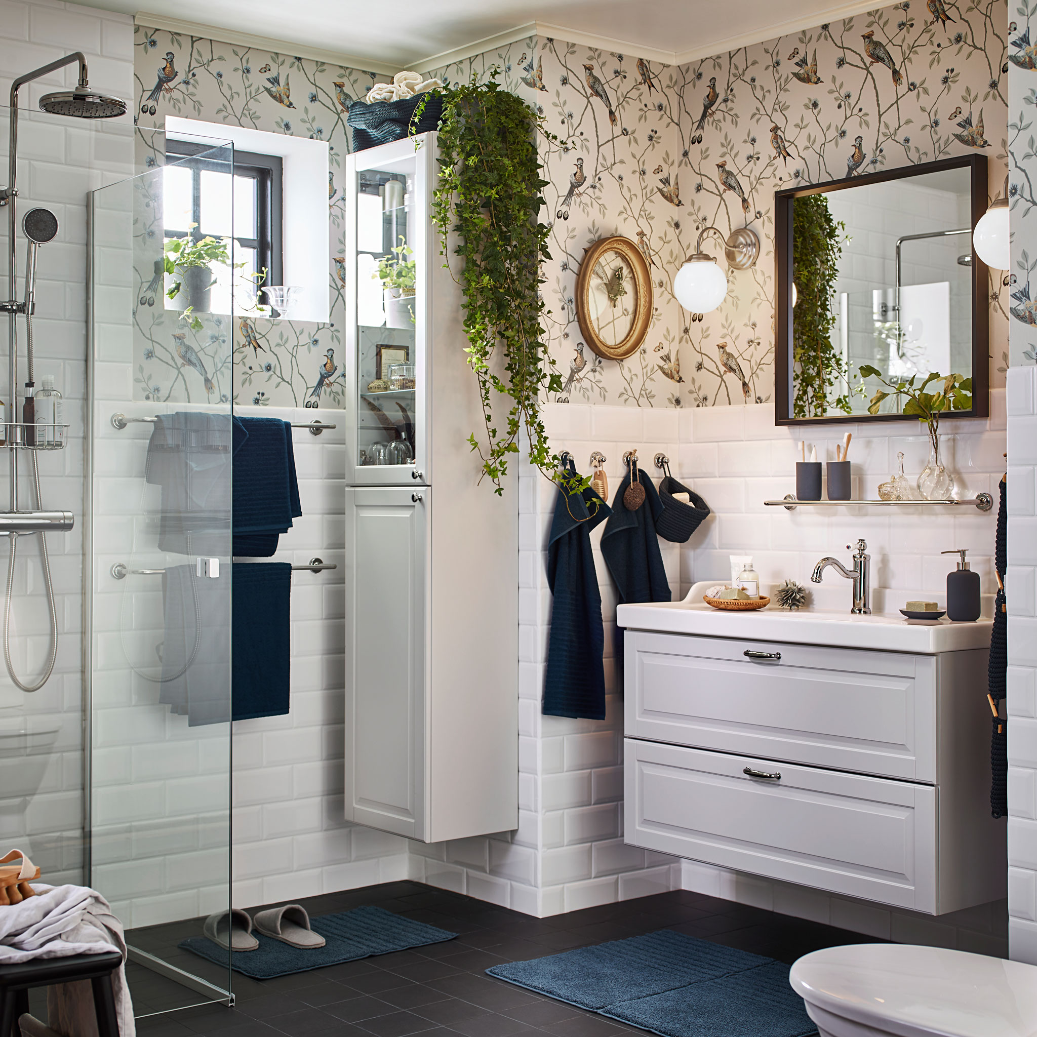 Create a relaxing atmosphere in your bathroom with IKEA GODMORGON white washbasin and white bathroom cabinet with glass doors. LILLHOLMEN nickel-plated wall lamps give a soothing warm glow for morning and night.