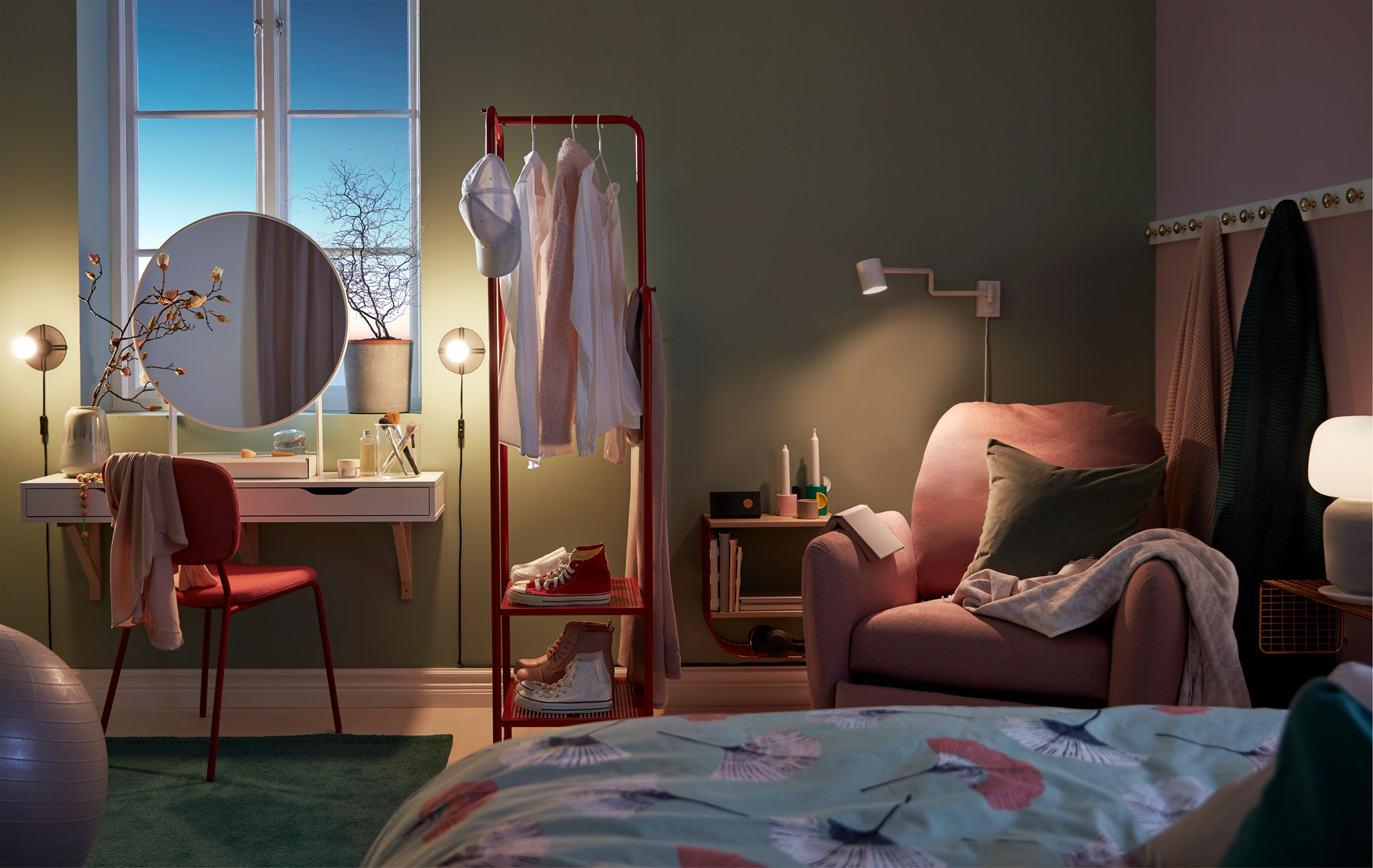 Dimly mood-lit bedroom with a make-up nook, room-dividing clothes rack and reading corner with recliner.