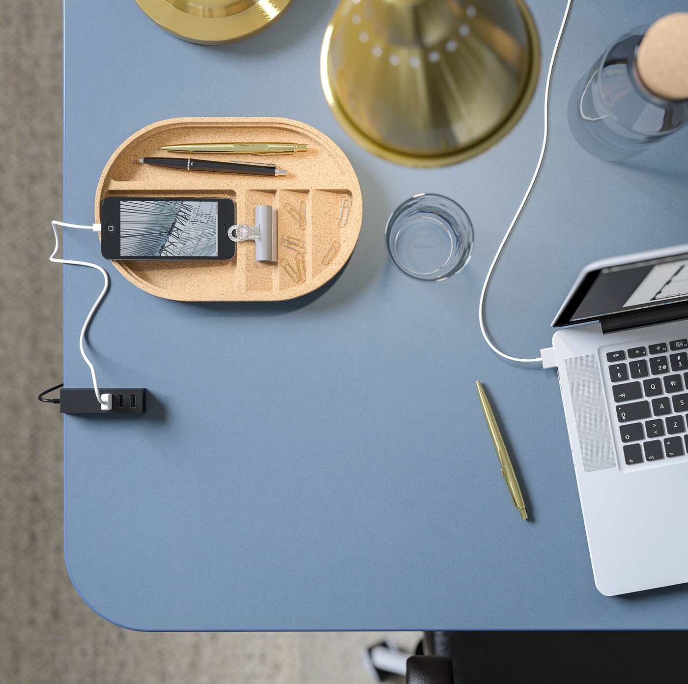 Closeup of a smooth IKEA BEKANT blue linoleum table top with a laptop, a phone and some office supplies.