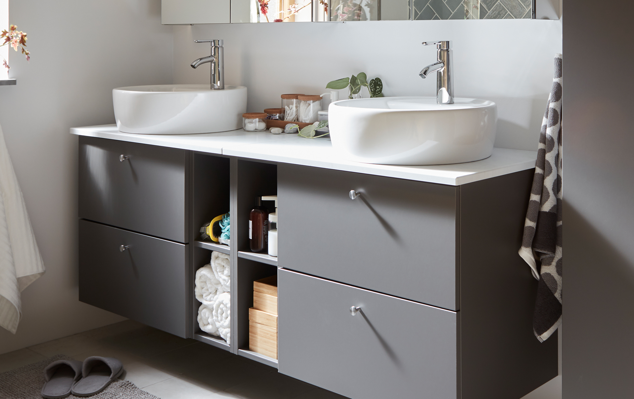 Grey GODMORGON/TOLKEN bathroom furniture with four drawers for hidden storage and four compartments for open storage.