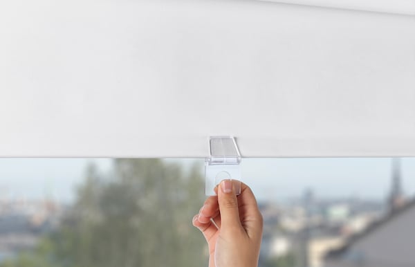 Hand pulling down a blind by the cord.
