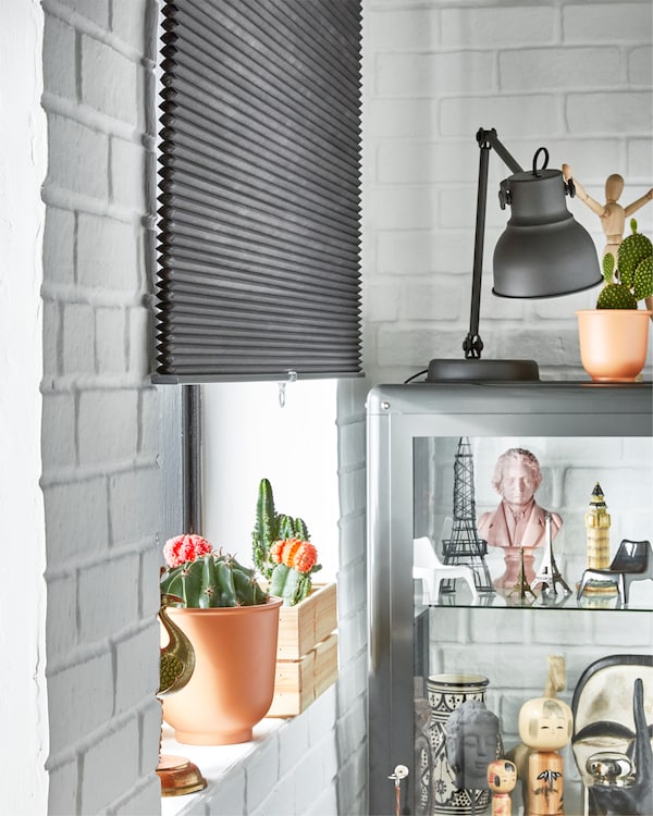 IKEA HOPPVALS grey room darkening cellular blind covers half of the window and helps darken the room both day and night.