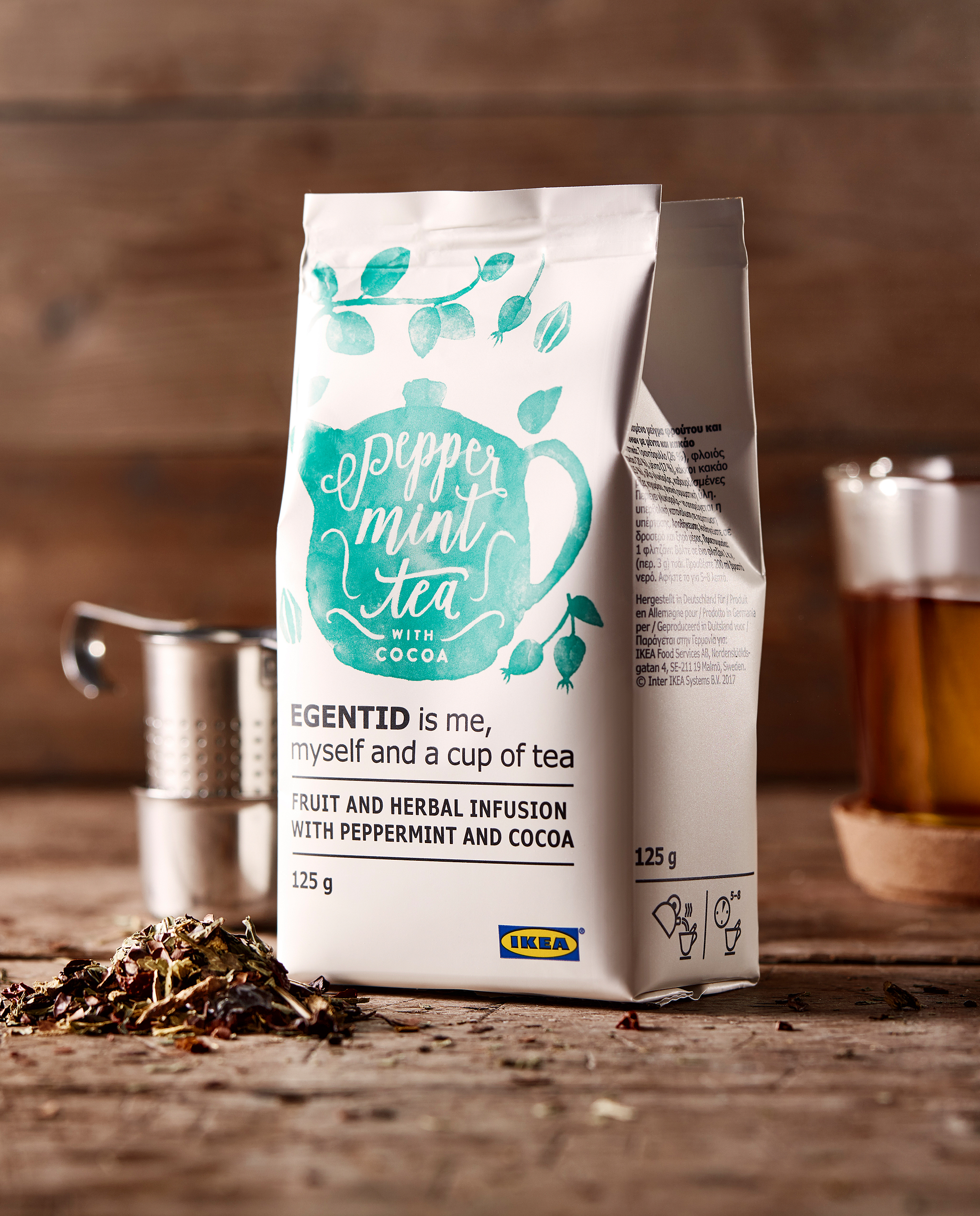 木材操作台面上放着一袋 EGENTID 依根提德 草本茶,四周是茶具套件和茶杯。