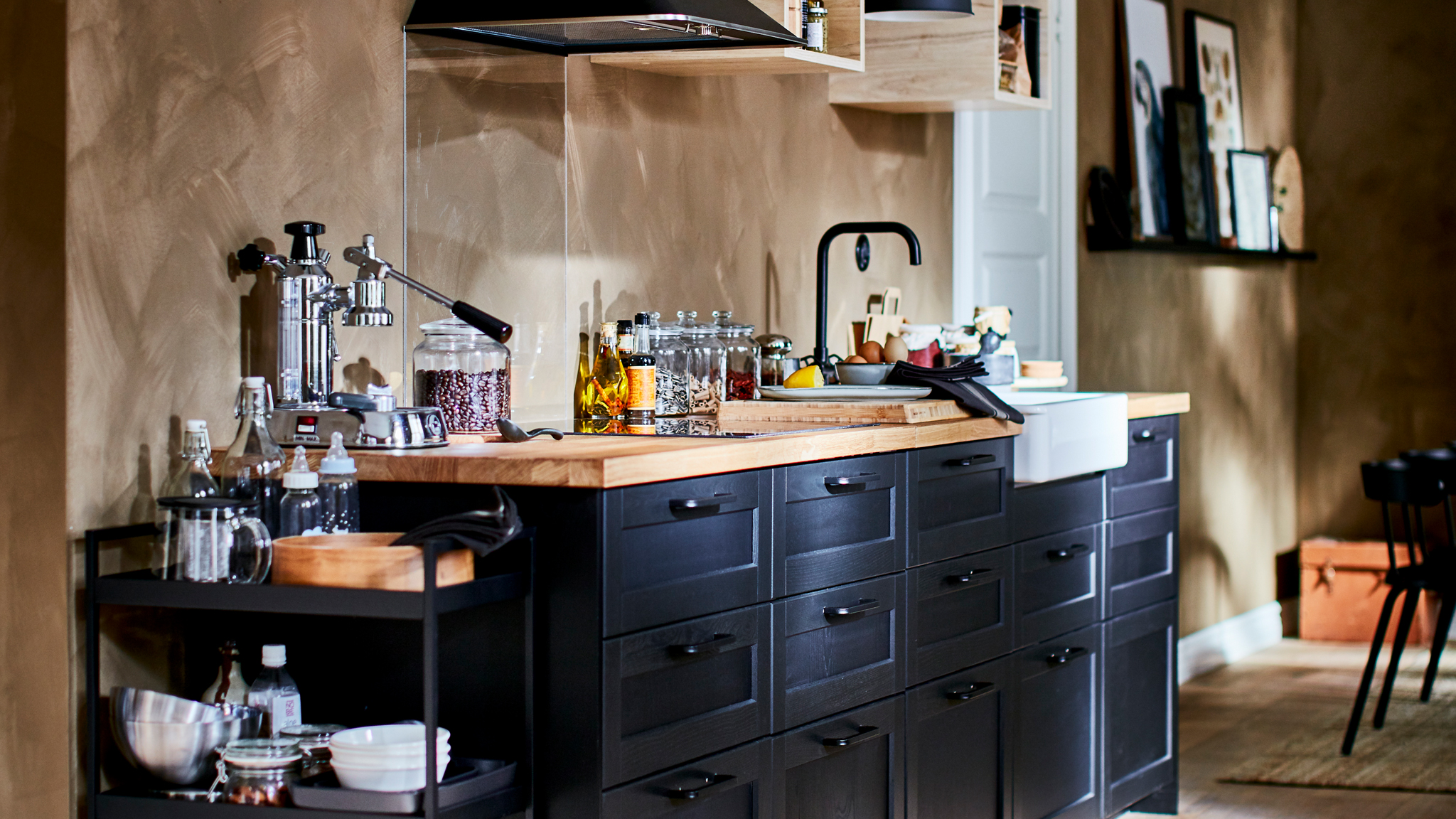 Richly equipped kitchenette with small, open wall cabinets, kitchen fan, and dark LERHYTTAN drawer fronts.