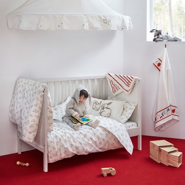 RÖDHAKE baby textile collection with a friendly pattern found on the quilt covers, a blanket, bed canopy and more.