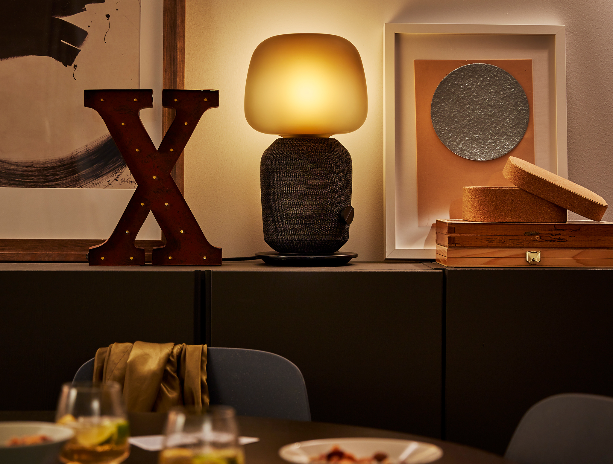 SYMFONISK lamp with WiFi speaker alongside decorative accessories on a dining room cabinet.