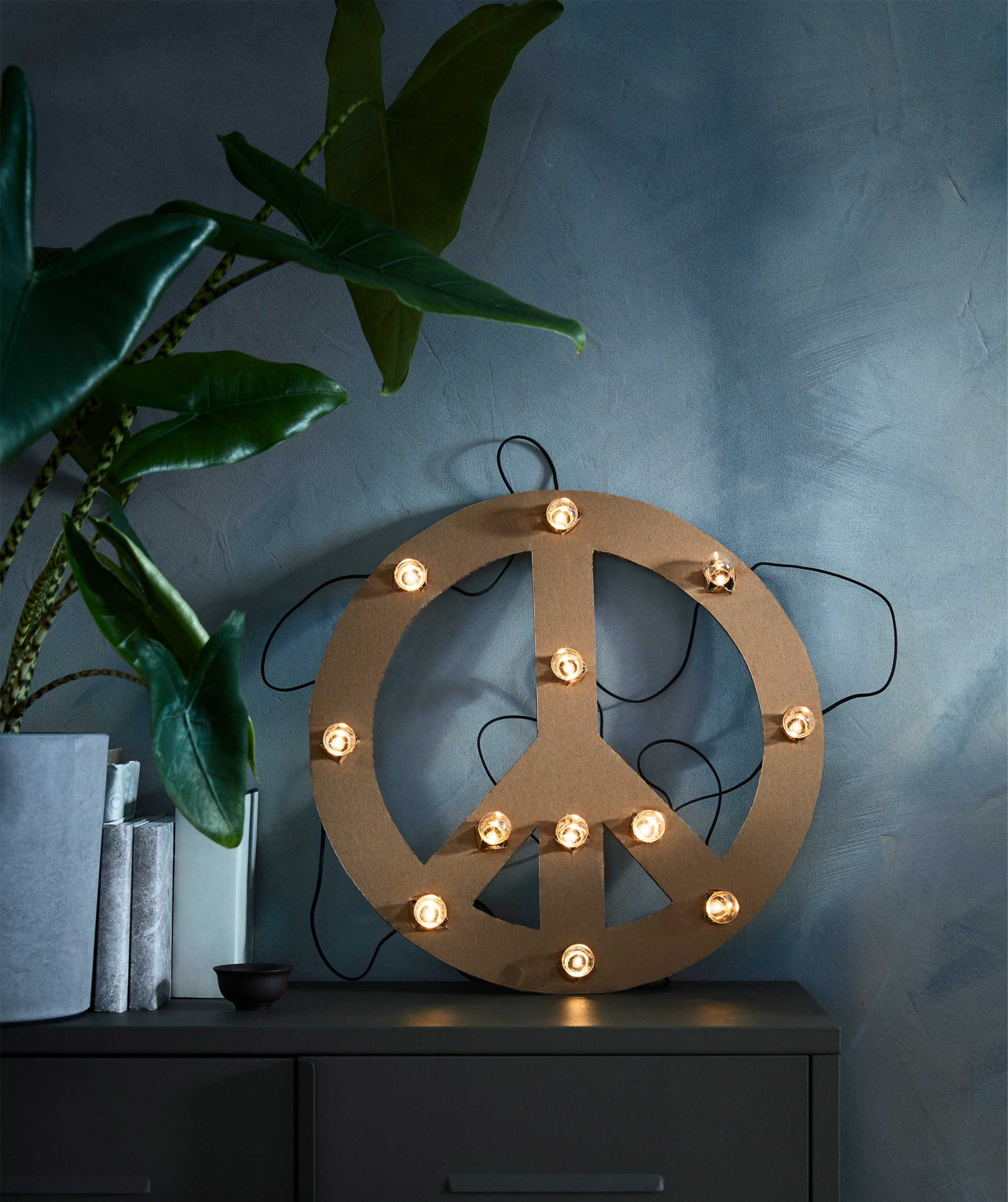 The black, battery operated BLÖTSNÖ LED lighting chain with 12 lights is intended for indoor use.