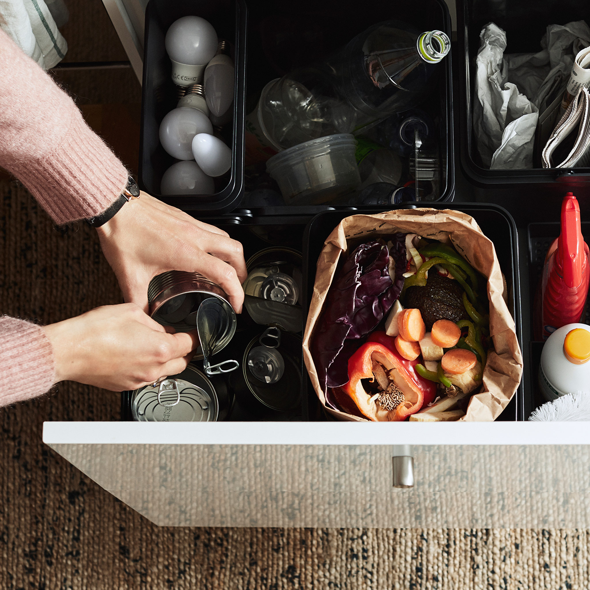 The contents of a can is being emptied and recycled in a drawer containing a VARIERA recycling system.