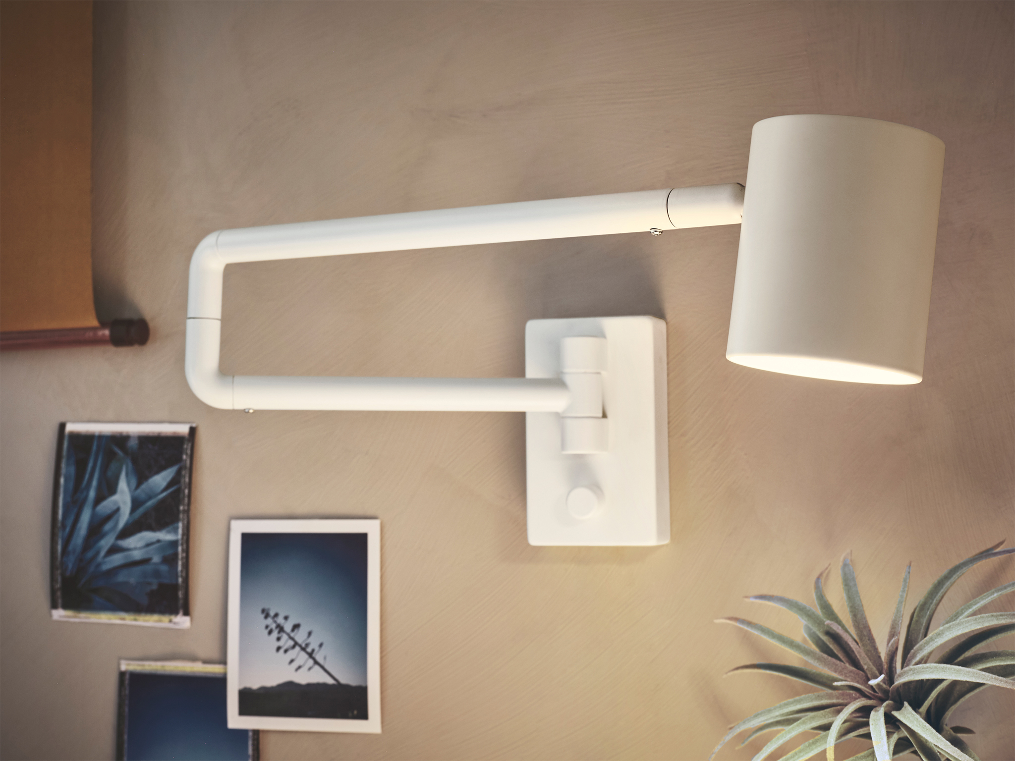 The design of NYMÅNE wall lamp makes it easy to direct. When not in use, it folds flat against the wall.