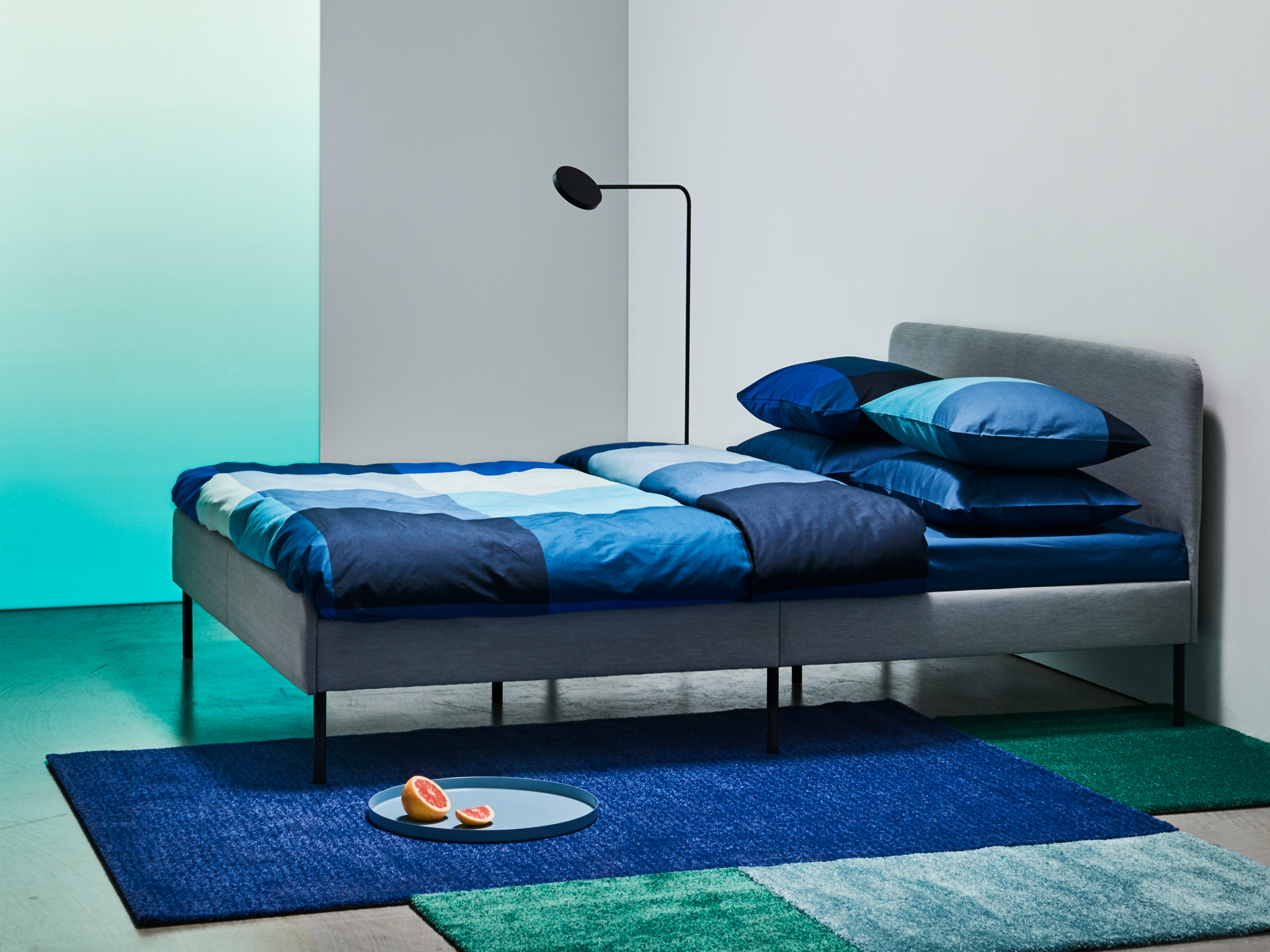 The grey SLATTUM upholstered bed with a padded headboard for extra comfort.