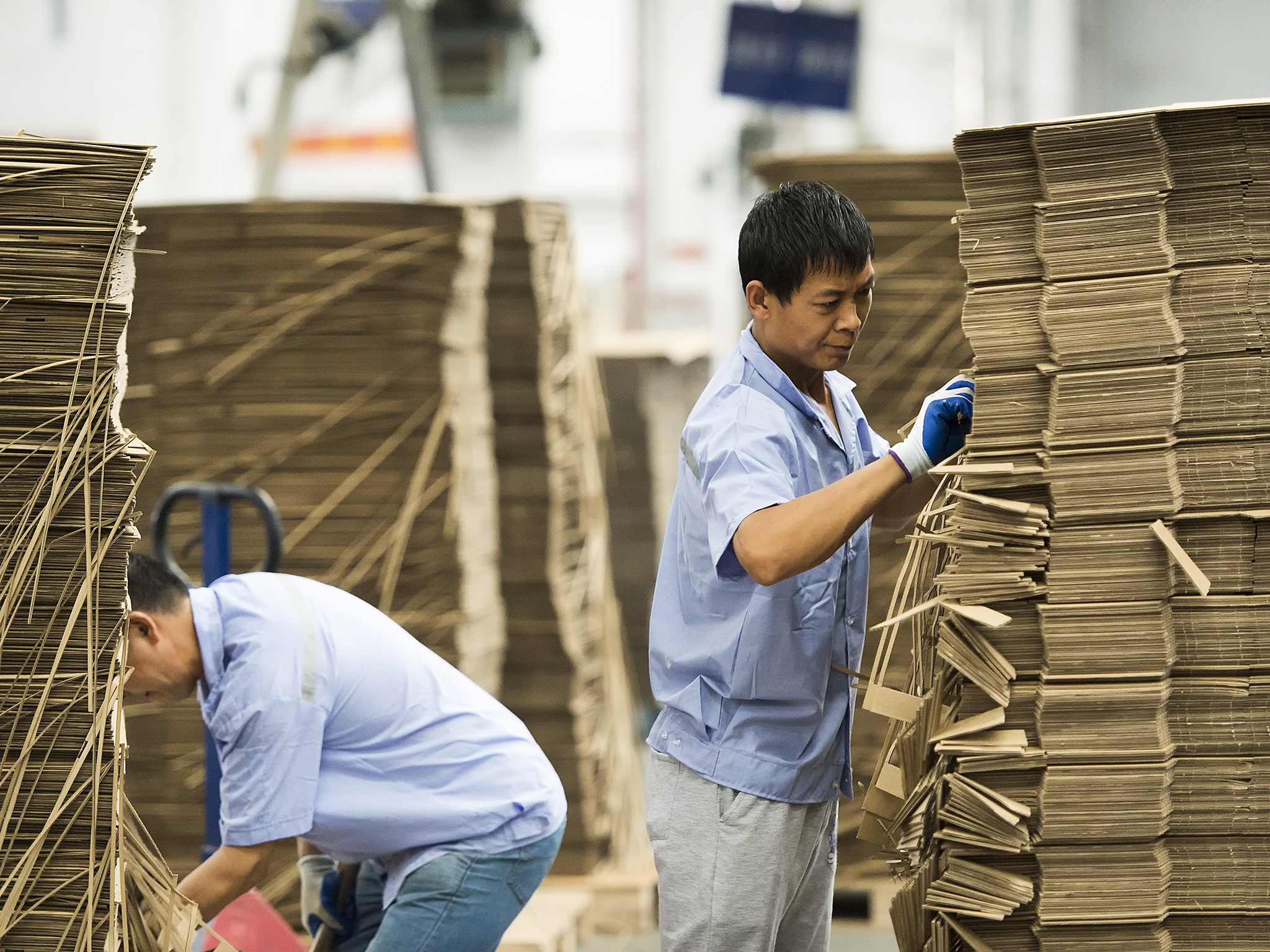 Two men sorting boxes at an IKEA supplier.