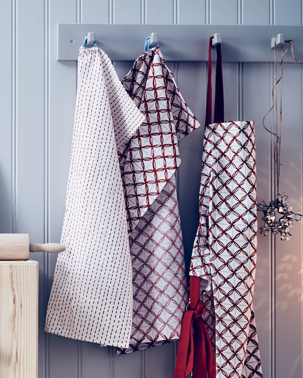 VINTERFEST towels hanging from a wall fitting with a red bag and Christmas decorations.