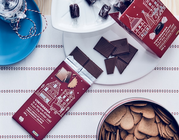 VINTERSAGA milk chocolate on a leaf-shaped VINTERFEST plate and heart-shaped cookies in a tin.